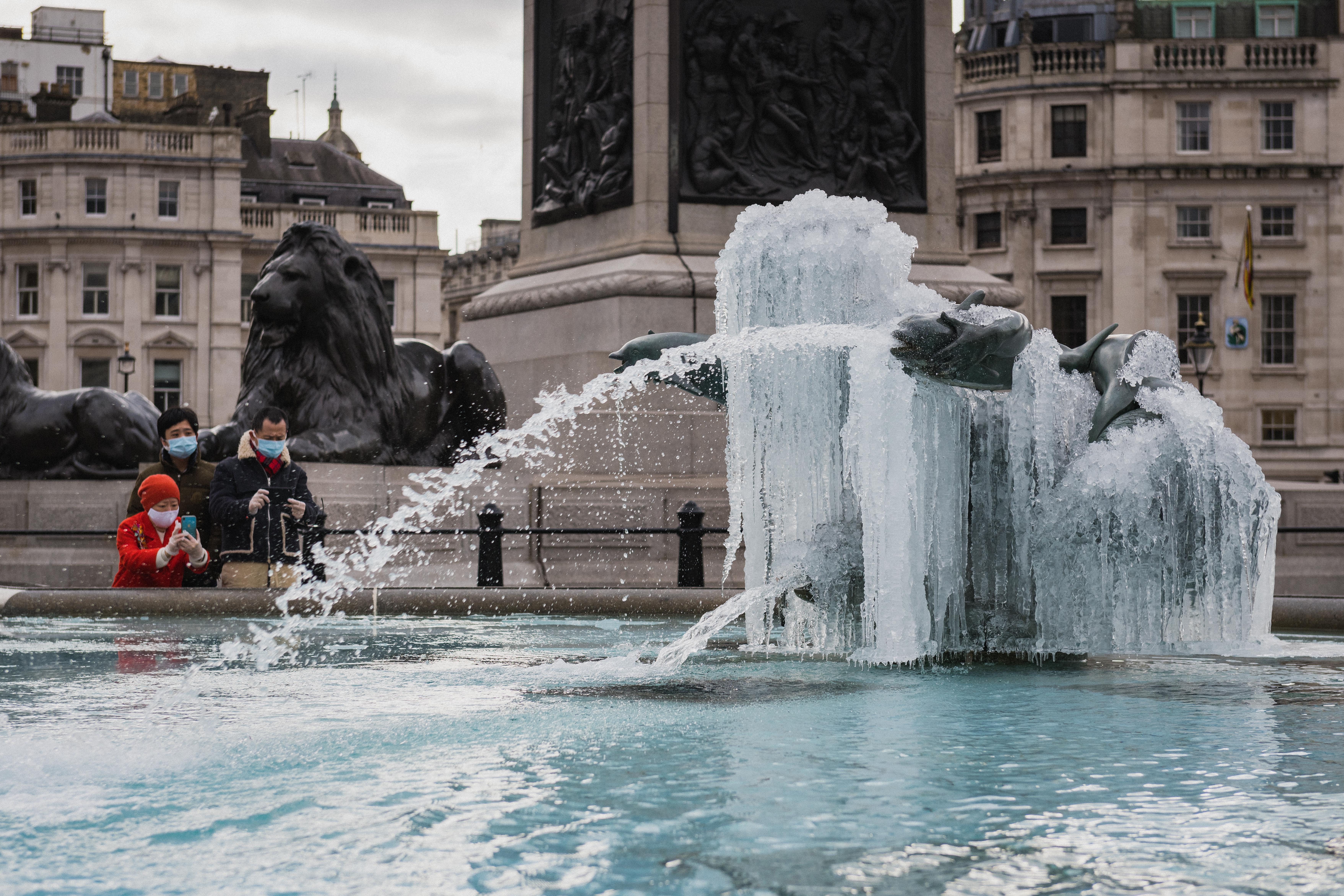 Members of the public take pictures of Icicles on the Trafalgar Square fountains as one of the coldest spells hit the UK this February in decades on February 12, 2021 in London, United Kingdom