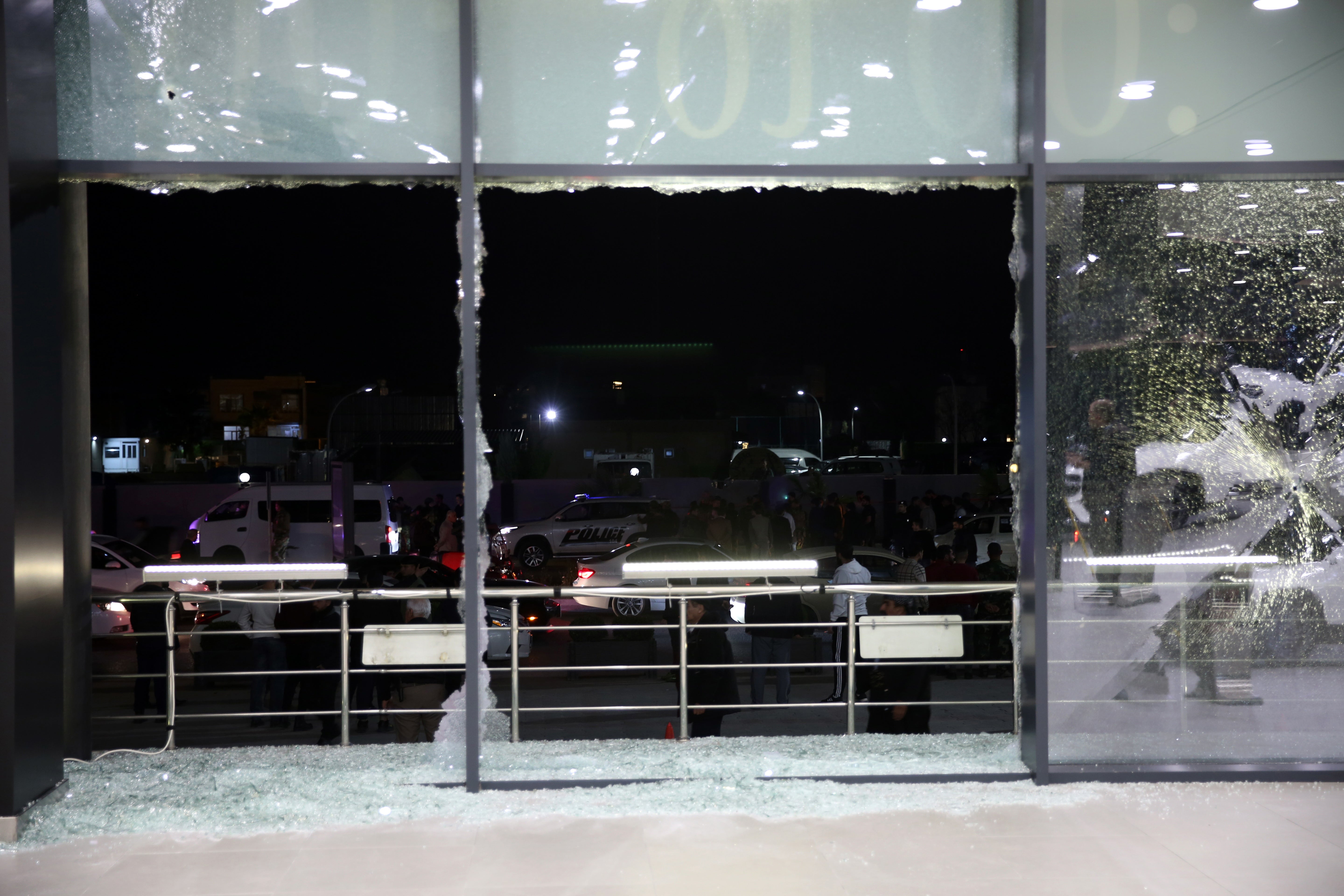 People look at damage caused by a rocket attack, at Erbil Airport