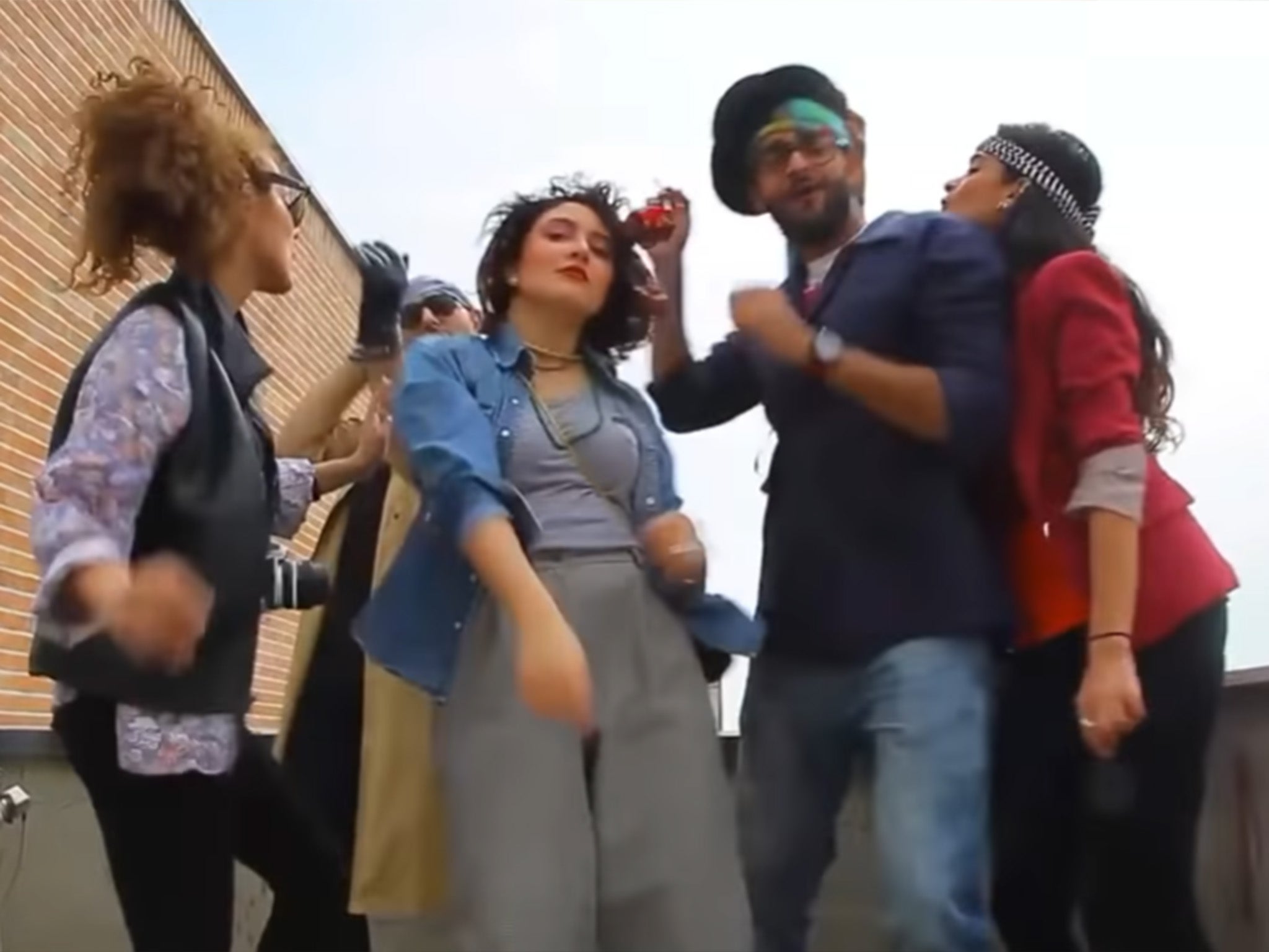 Taravati (centre) dancing with her friends on the Tehran rooftops to the song ‘Happy’