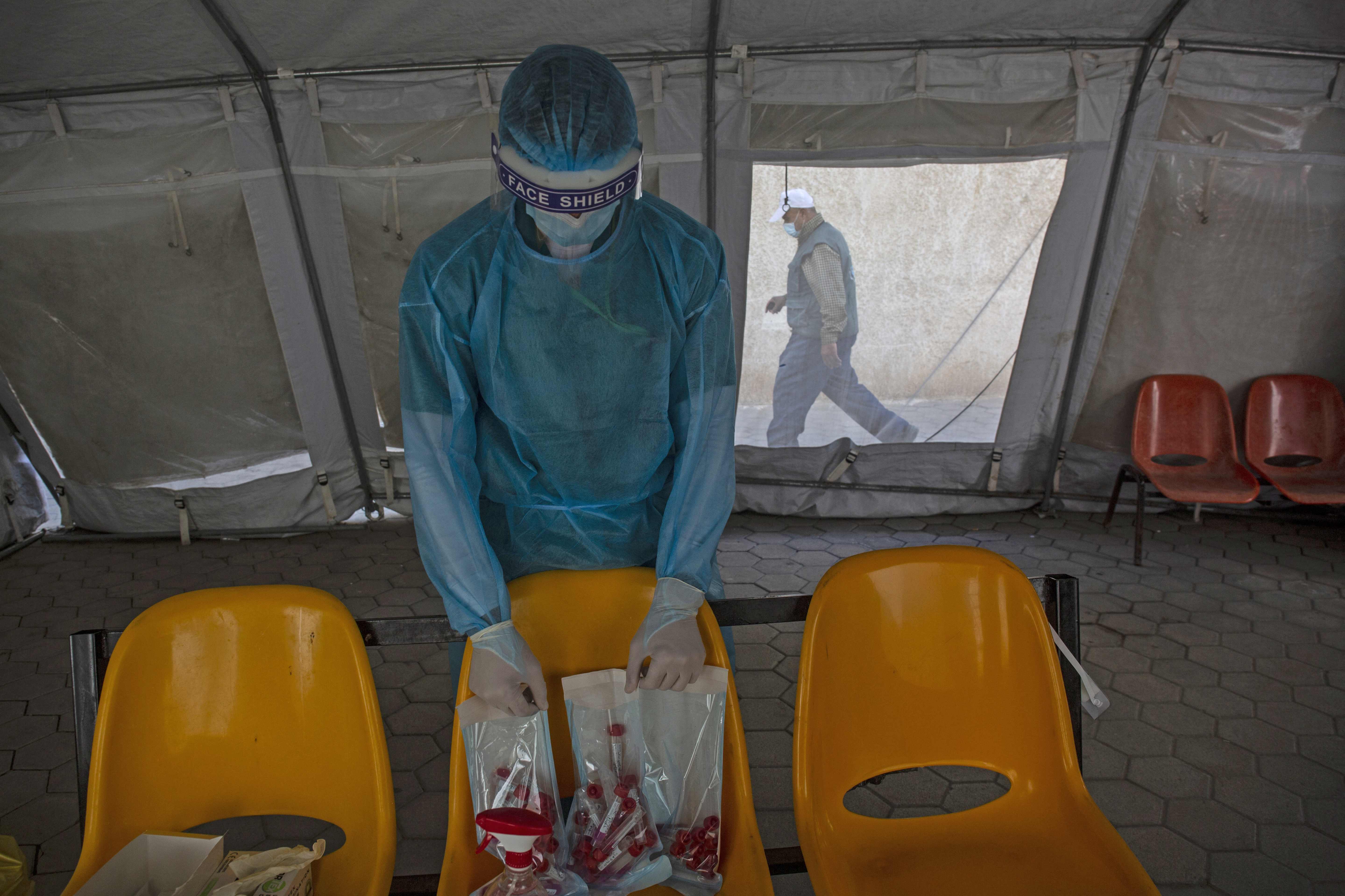 A Palestinian health worker arranges swab samples collected to test for Covid-19 in Rafah