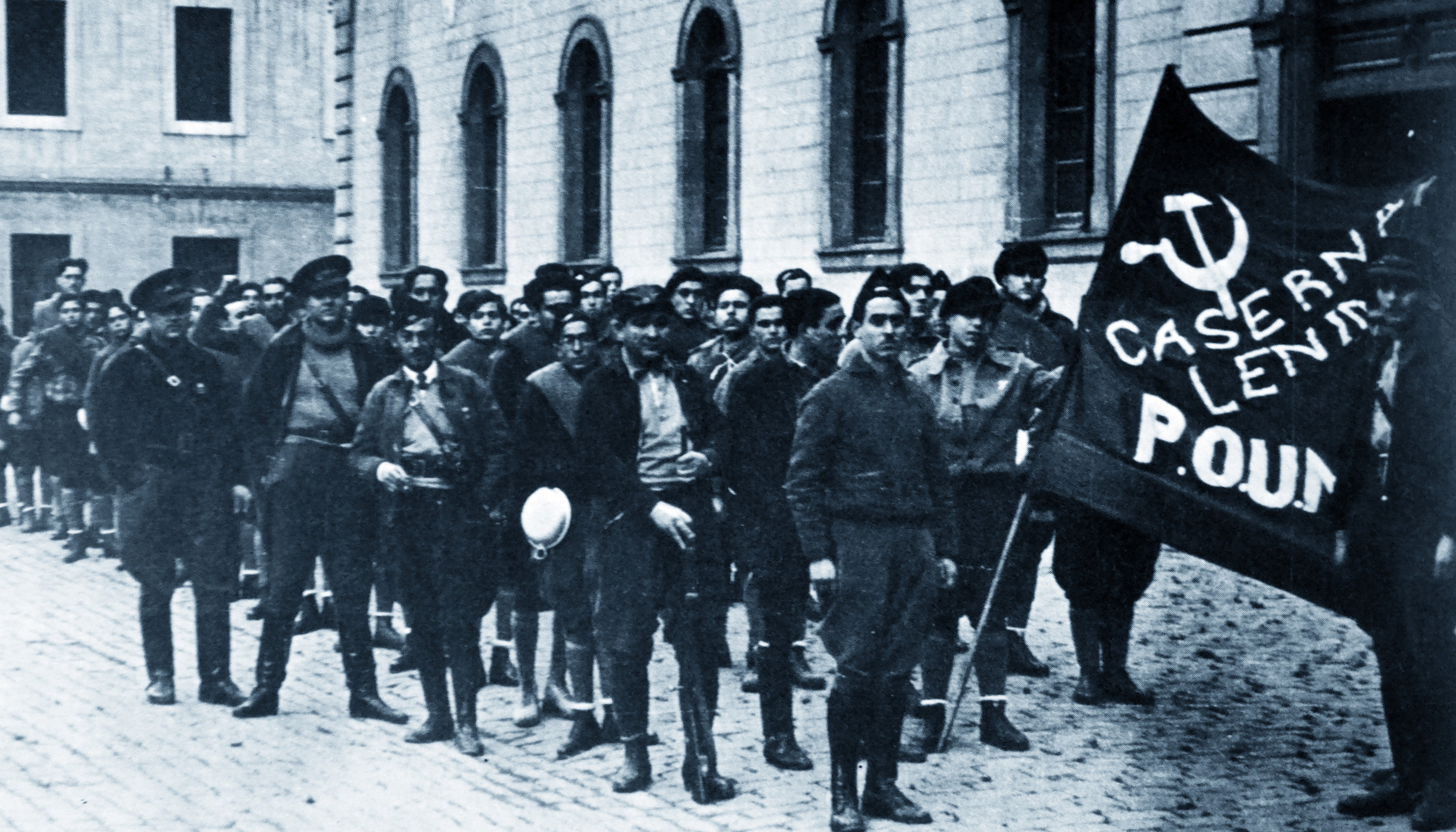 Militia members guard the headquarters of the POUM, a communist party, in Barcelona in 1936. In the background stands George Orwell