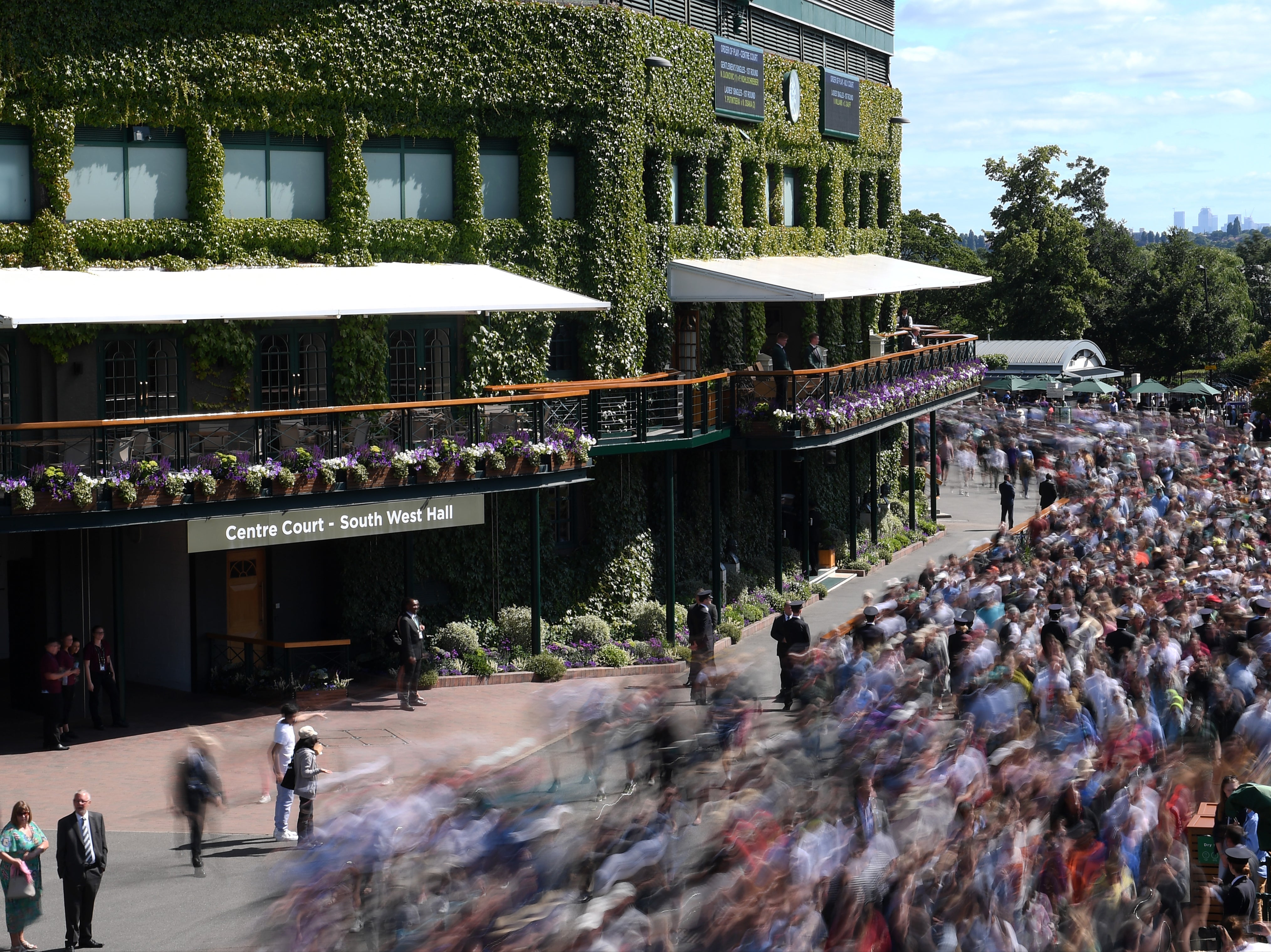 Fans arrive inside the grounds at the All England Lawn Tennis and Croquet Club