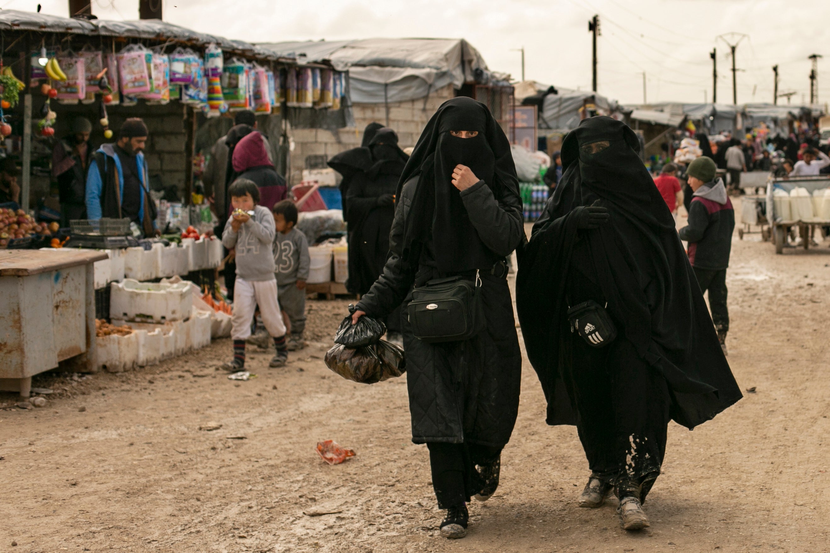 Women shop in the marketplace at al-Hol camp