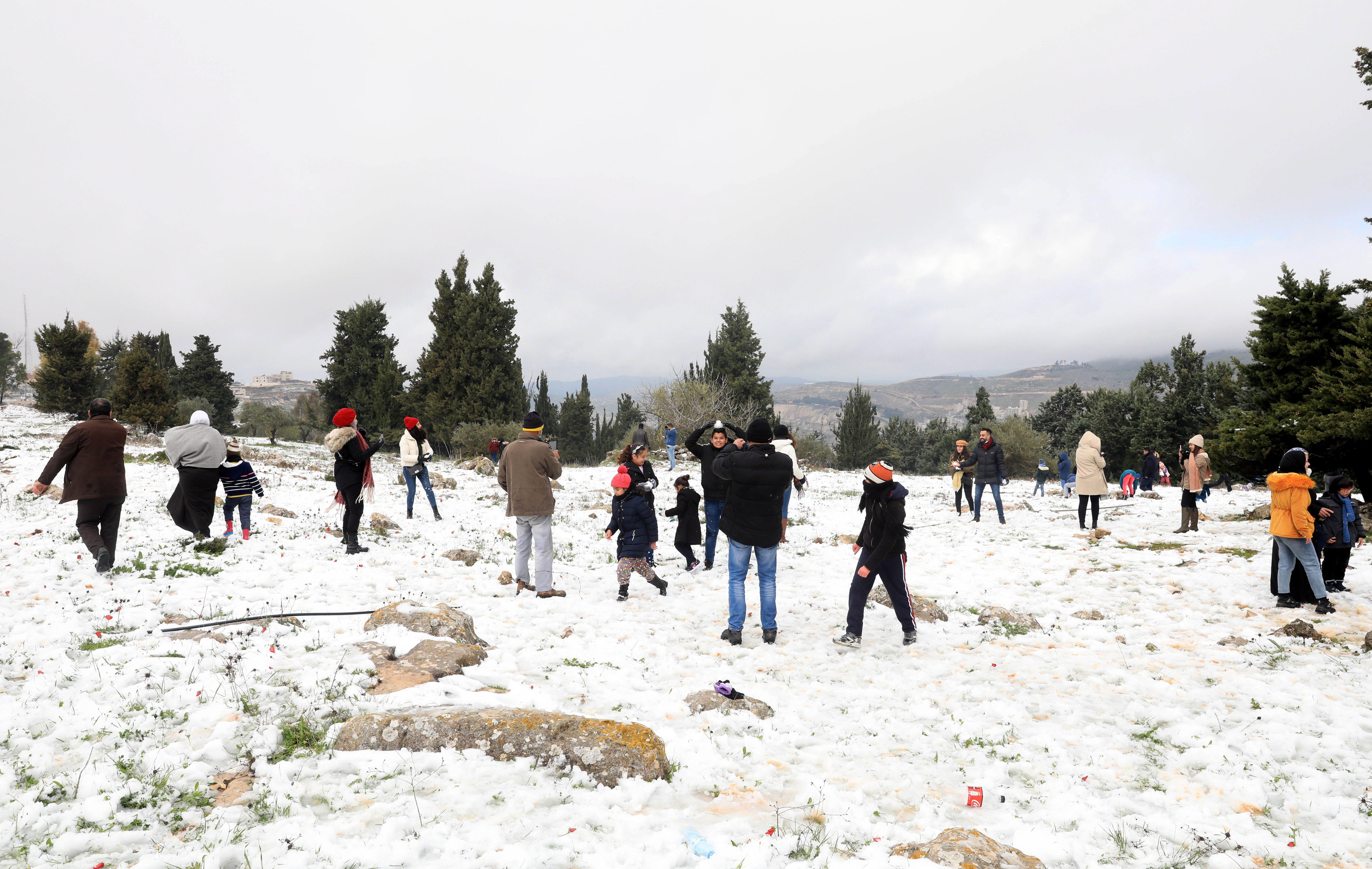 Palestinians have a snow ball fight on Mount Jerzim during a snow day near Nablus, West Bank