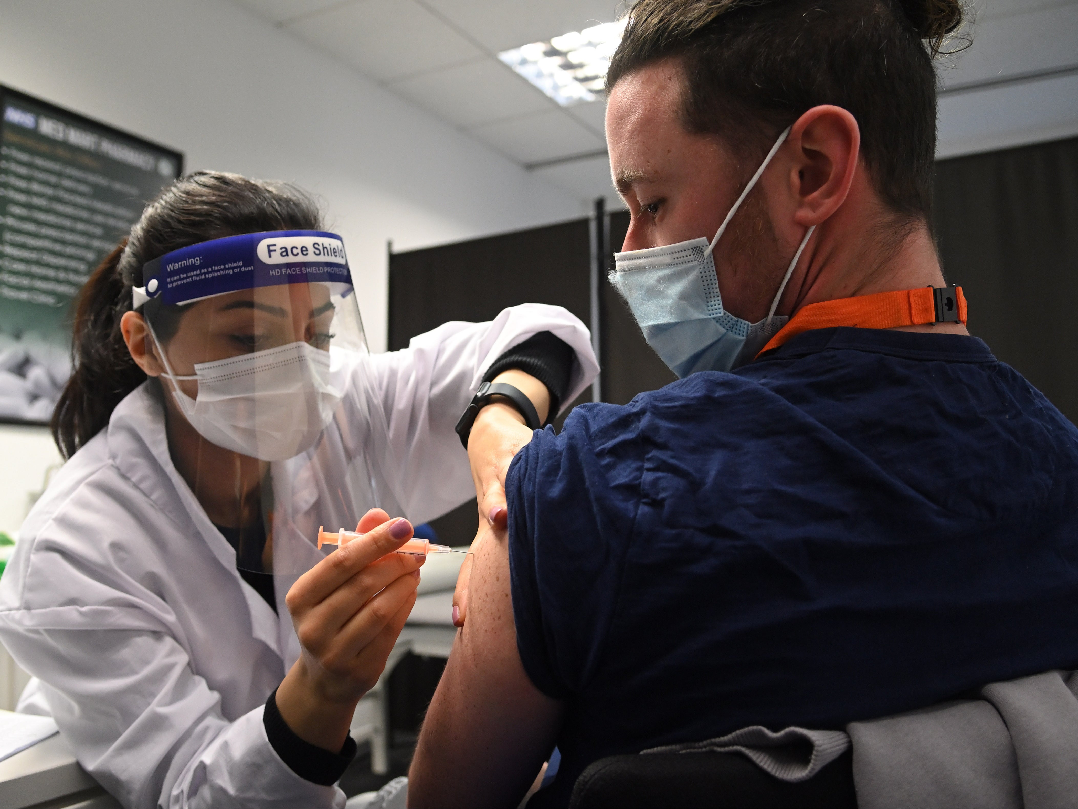 Care worker Jordan Lewis (right) receives the Oxford vaccine at Borehamwood