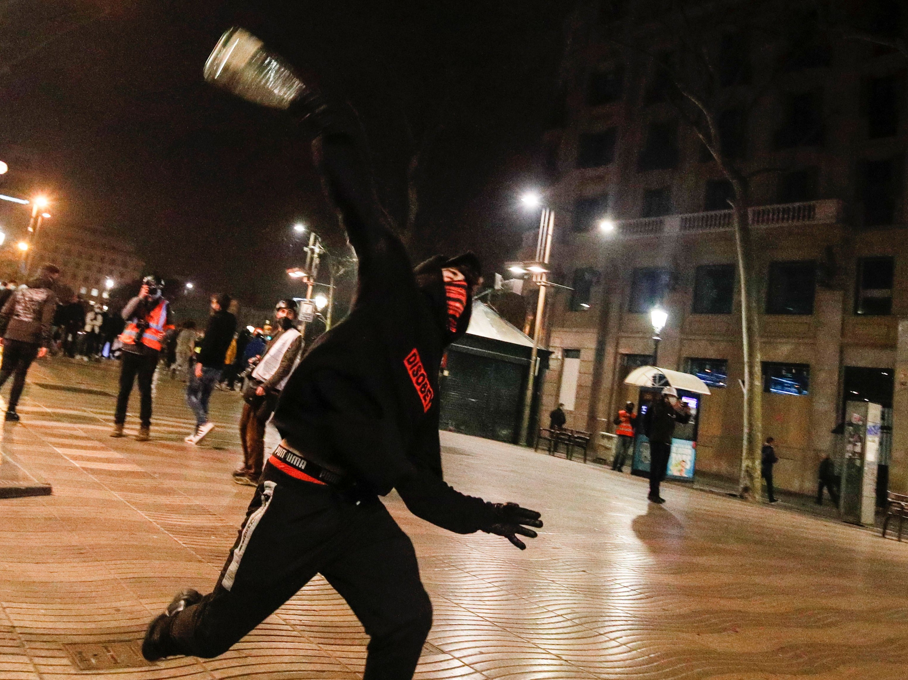 A demonstrator throws an object during a protest in support of Catalan rapper Pablo Hasel