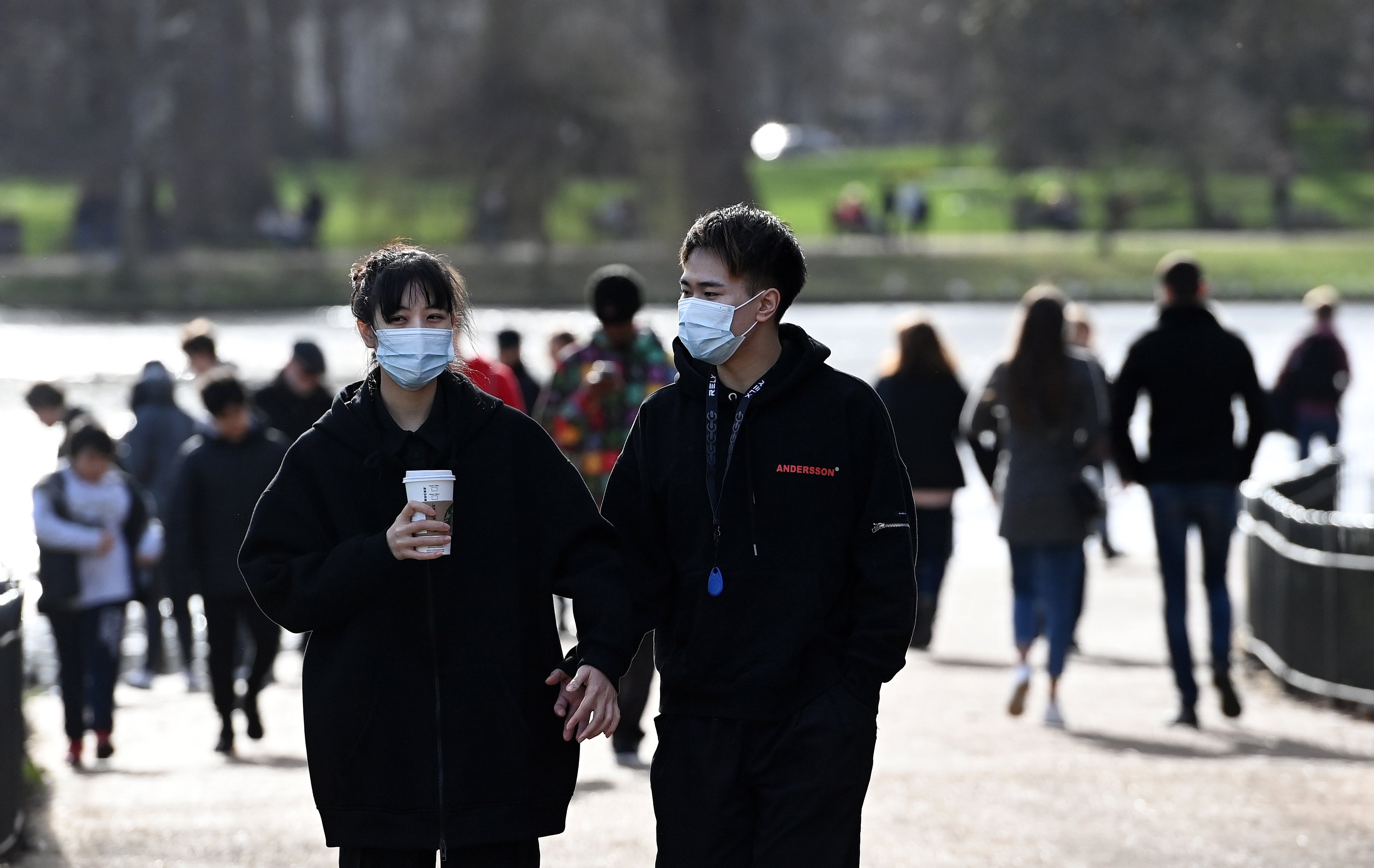 People enjoy the spring-like weather at a park in London