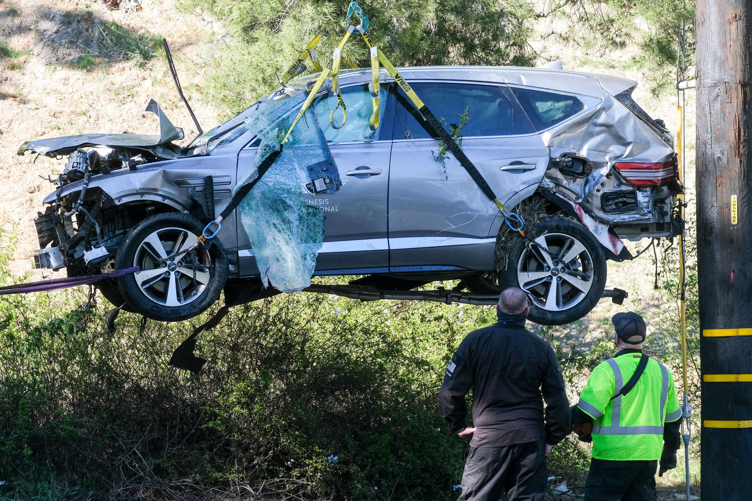 A crane is used to remove Tiger Woods’ car after the crash