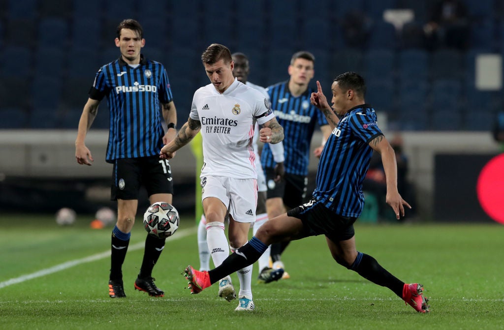 Toni Kroos of Real Madrid is tackled by Luis Muriel