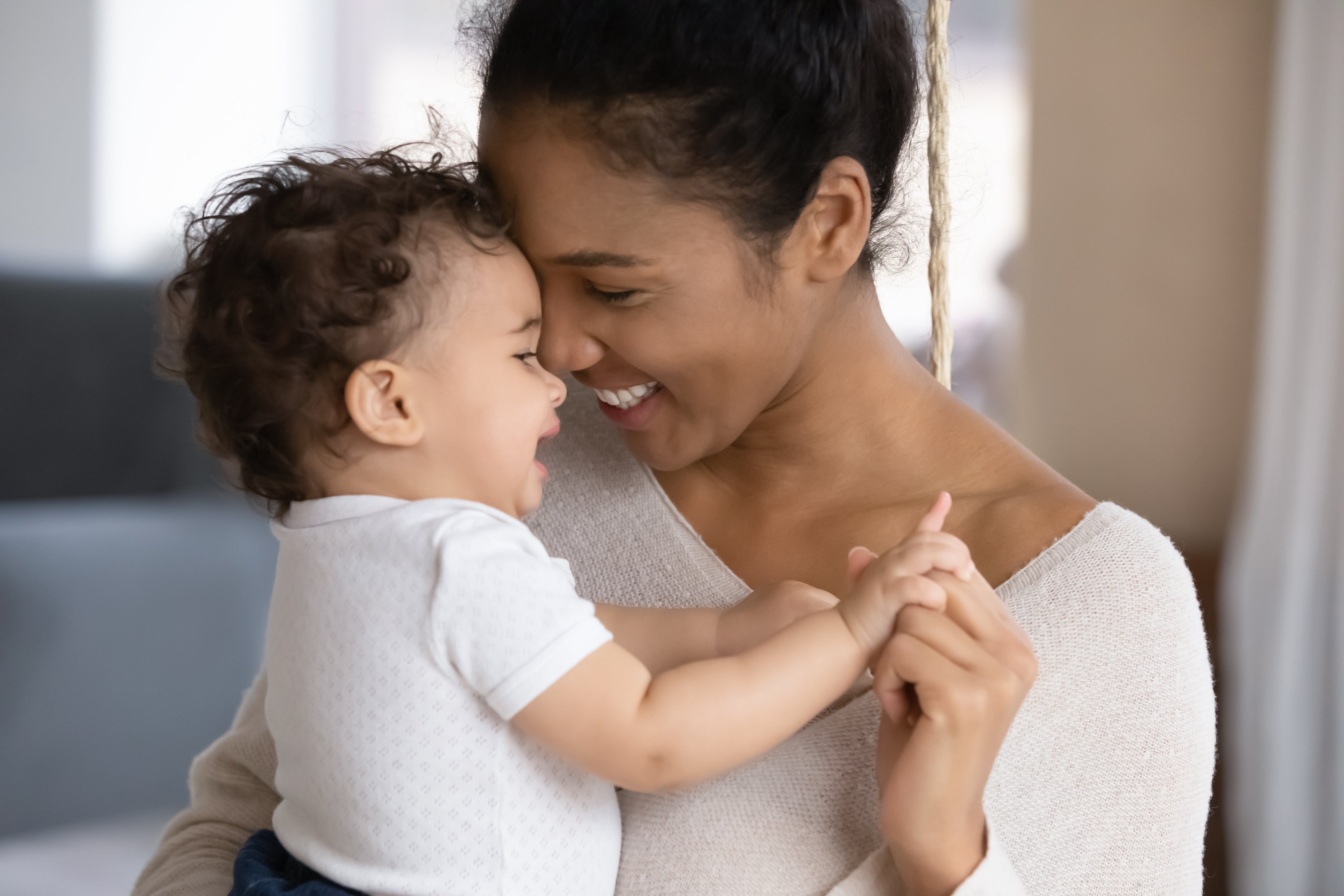 Smiling mixed race mum holding baby