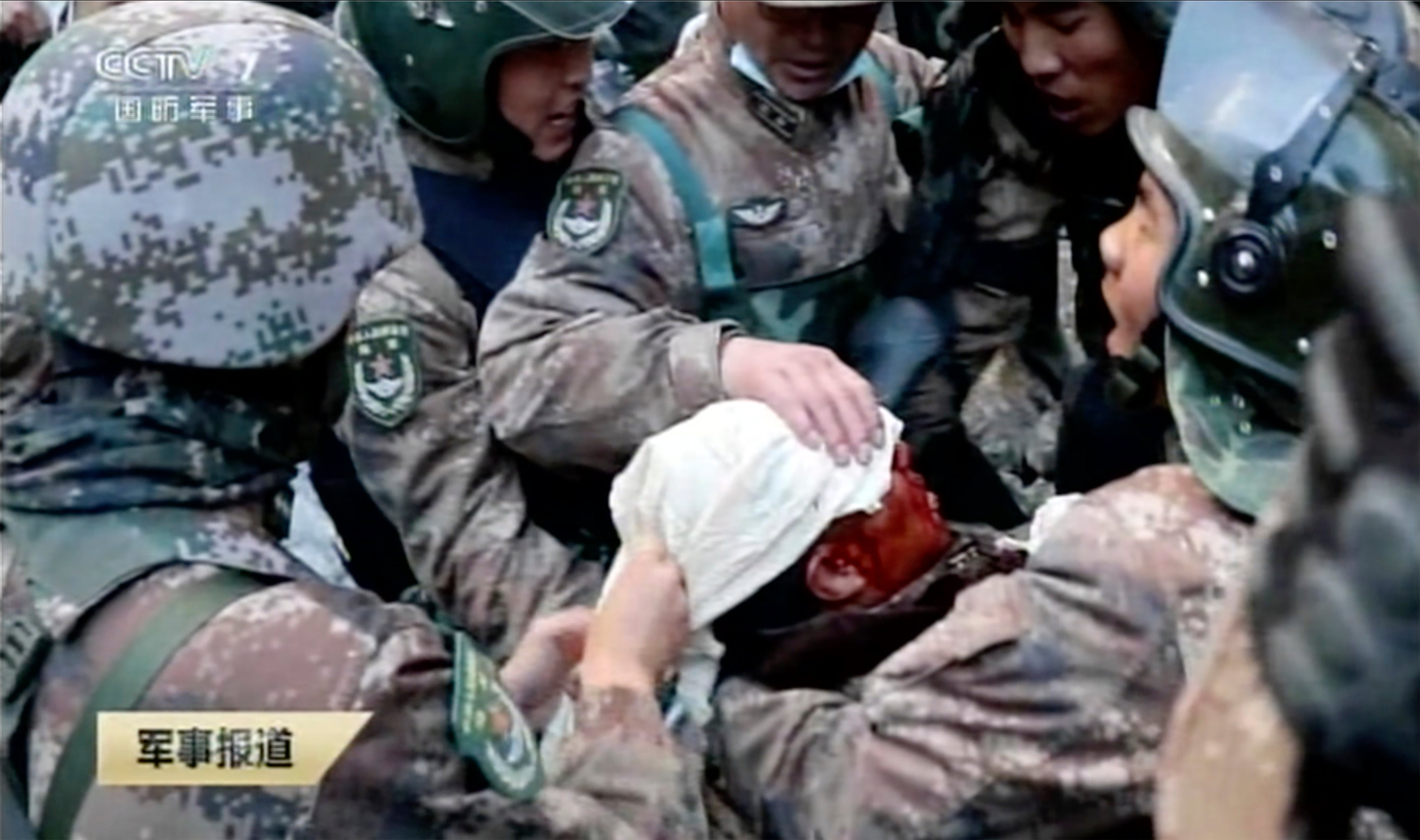 In this image taken from video footage run 19 February 2021 by China's CCTV via AP Video, soldiers bandage the head of China's People’s Liberation Army (PLA) regimental commander Qi Fabao