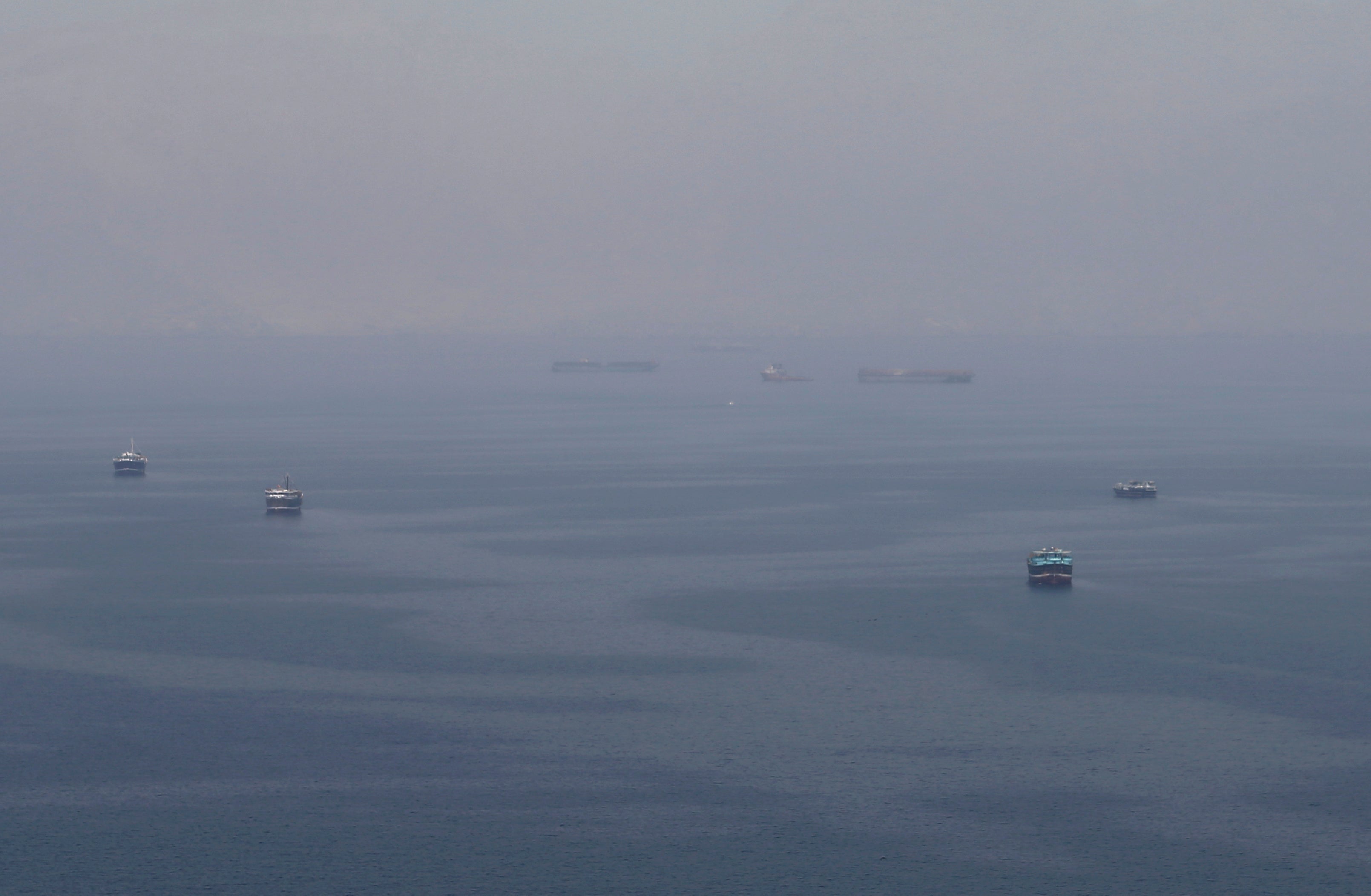 File photo shows traditional Omani boats known as dhows, and cargo ships sailing towards the Strait of Hormuz in the Gulf of Oman