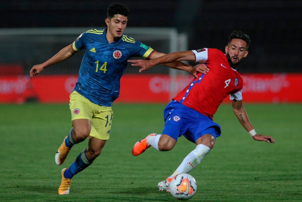 Stevan Alzate battles with Mauricio Isla for the ball