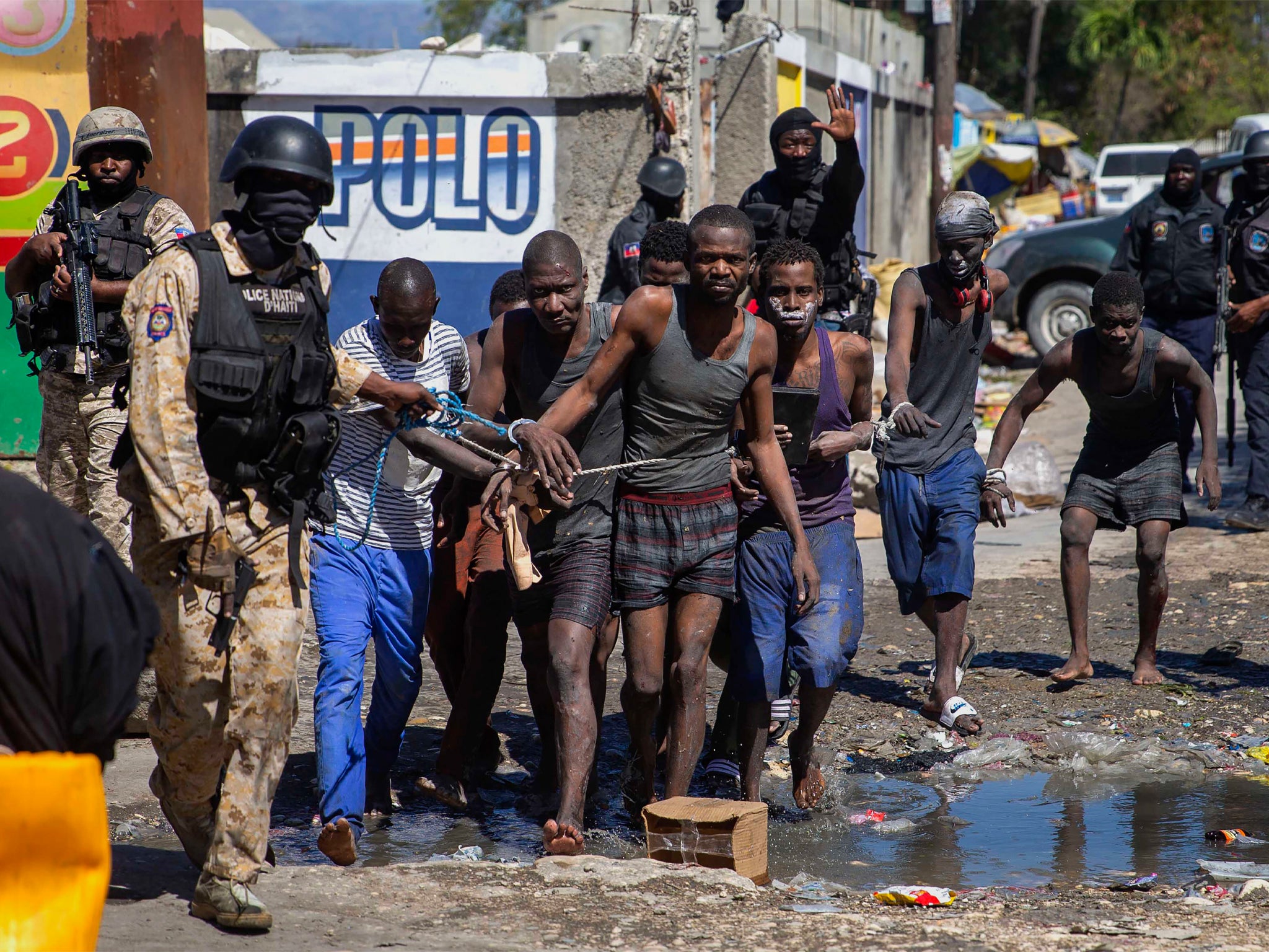 Recaptured inmates led by police outside the Croix-des-Bouquets Civil Prison