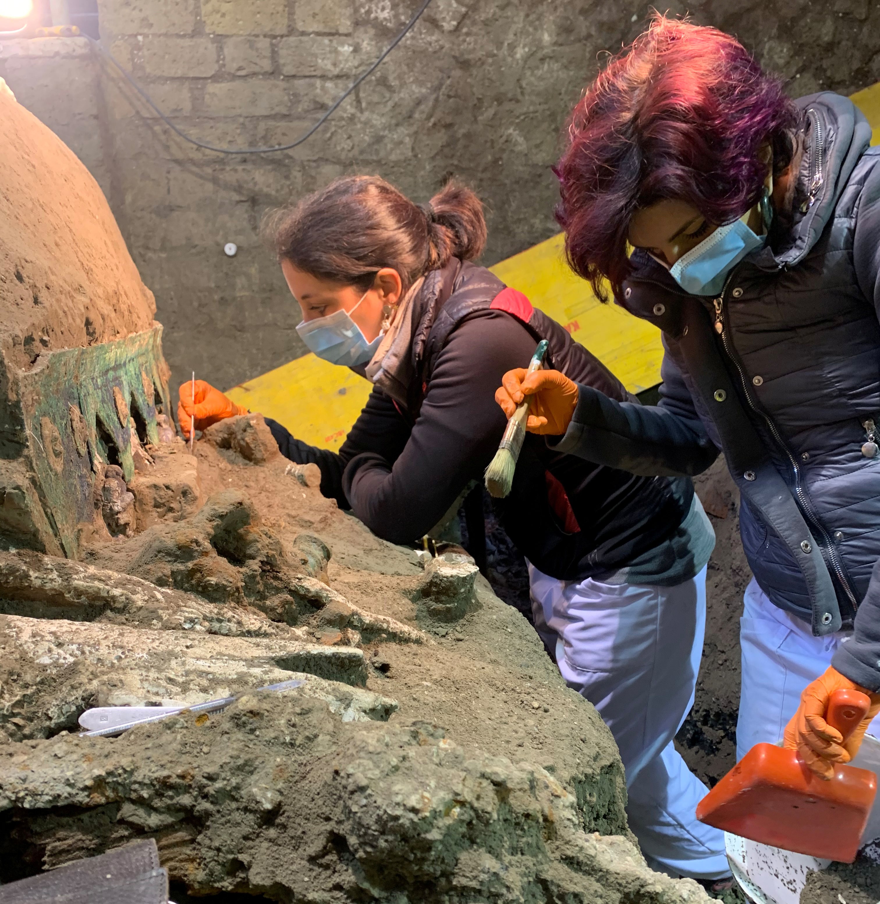 Archaeologists work on the almost-intact ancient ceremonial carriage