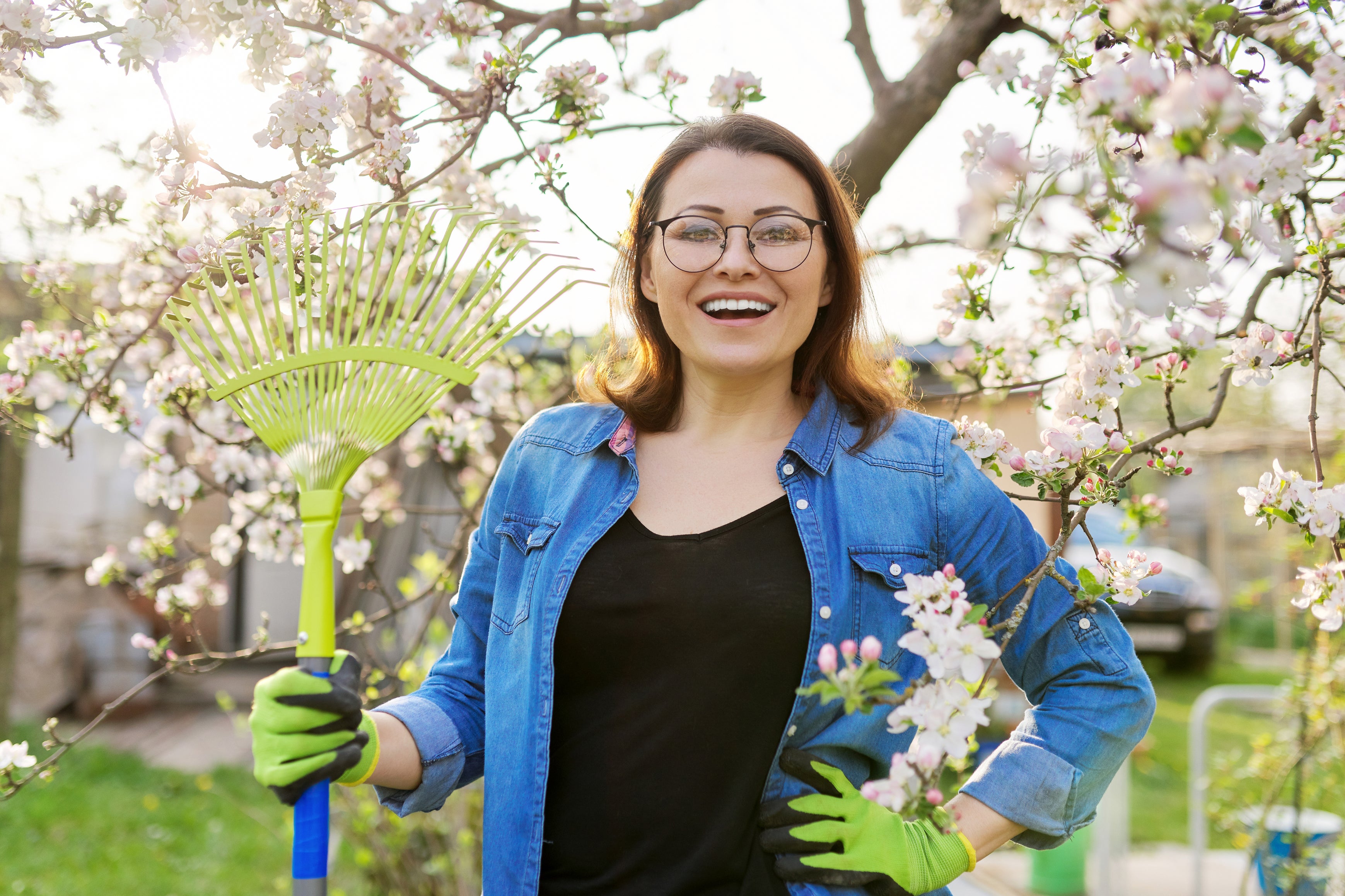 A woman with a rake in a spring garden (iStock/PA)