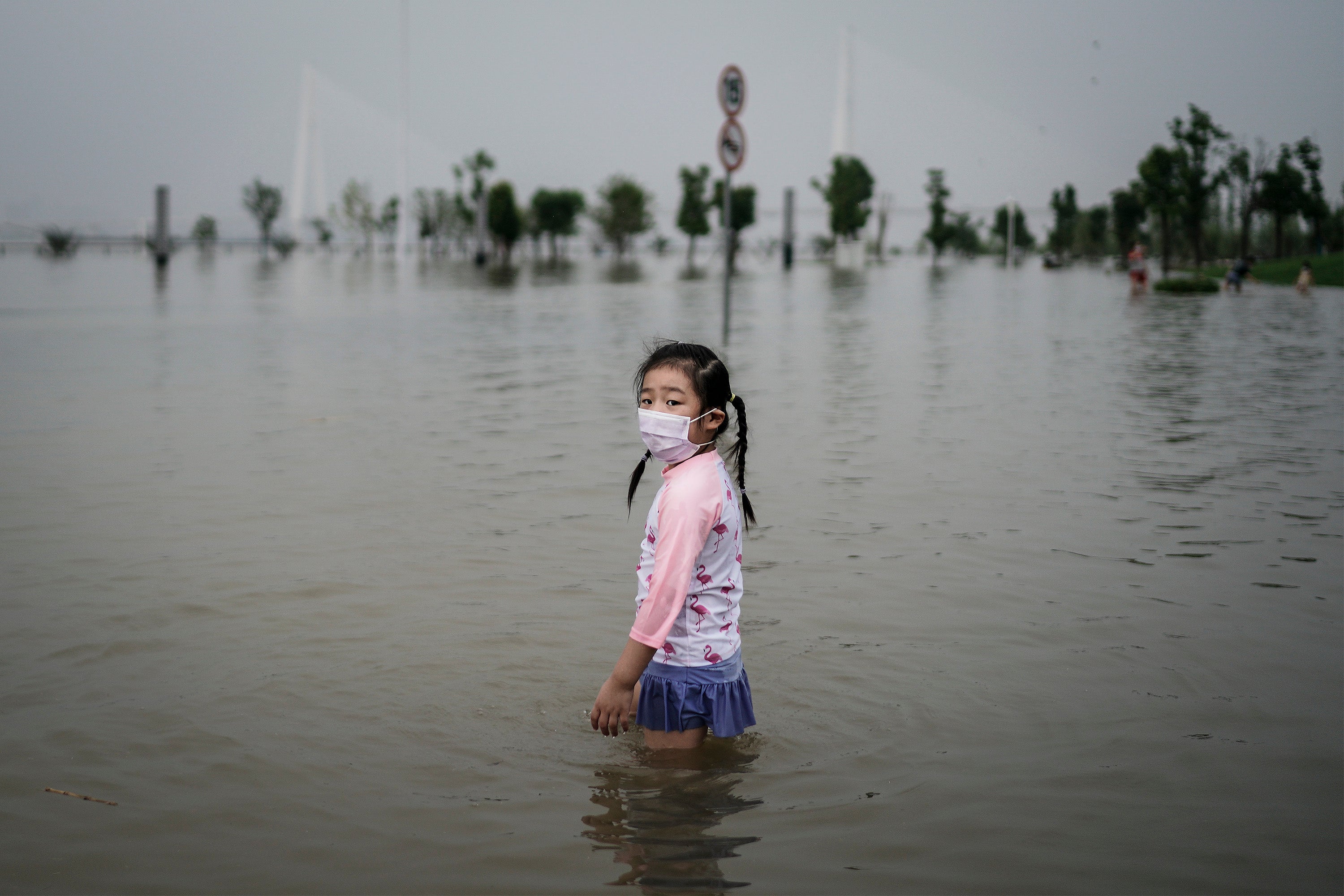 A young girl plays in the flooded Jiangtan park caused by heavy rains along the Yangtze river