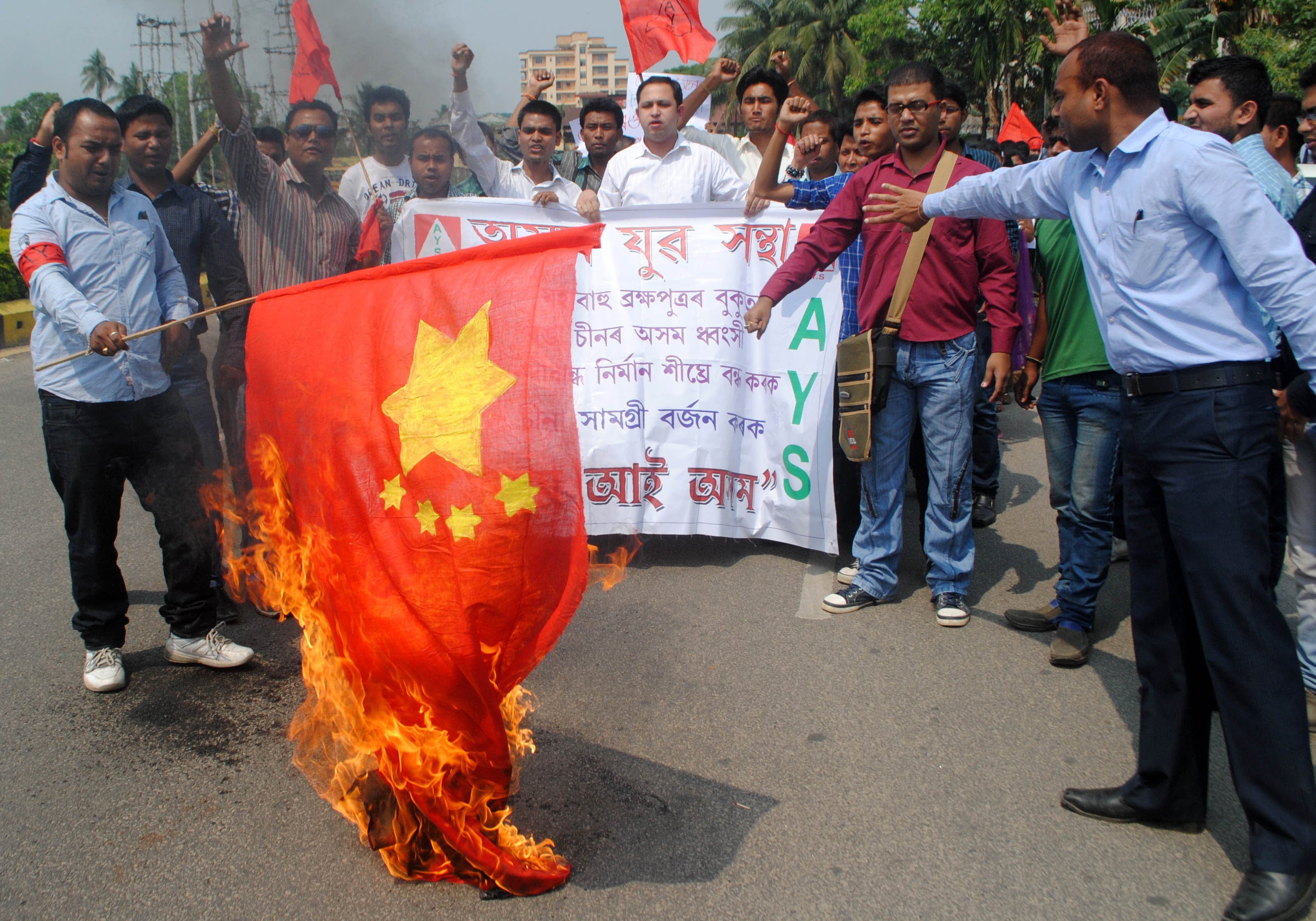 Activists burn a Chinese flag during a protest in Guwahati against the proposed construction of dams on the middle reaches of the River Brahmaputra in China, part of a hydropower project