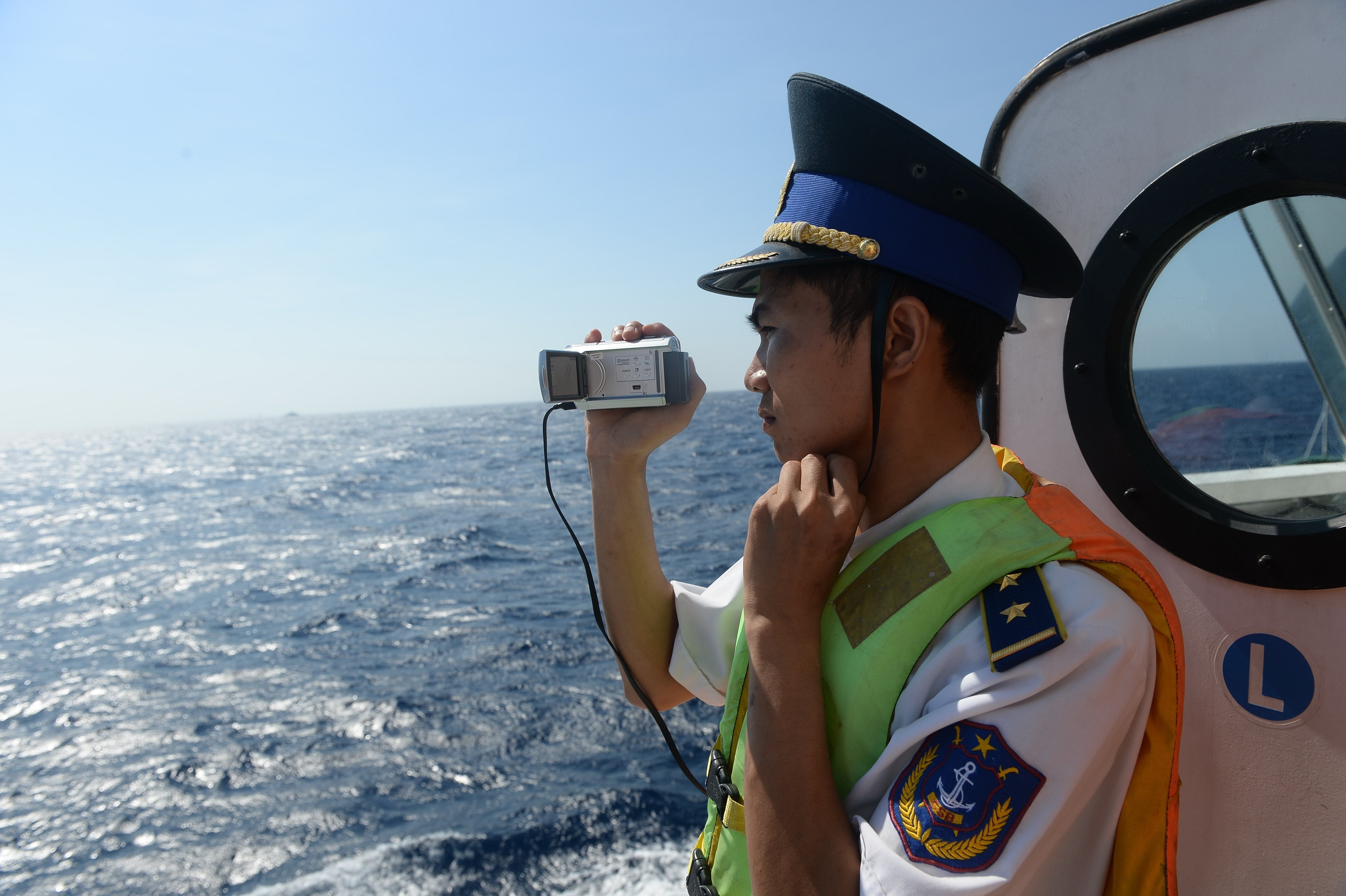 A Vietnamese coast guard taking pictures of a Chinese vessel near China’s oil drilling rig in disputed waters in the South China Sea