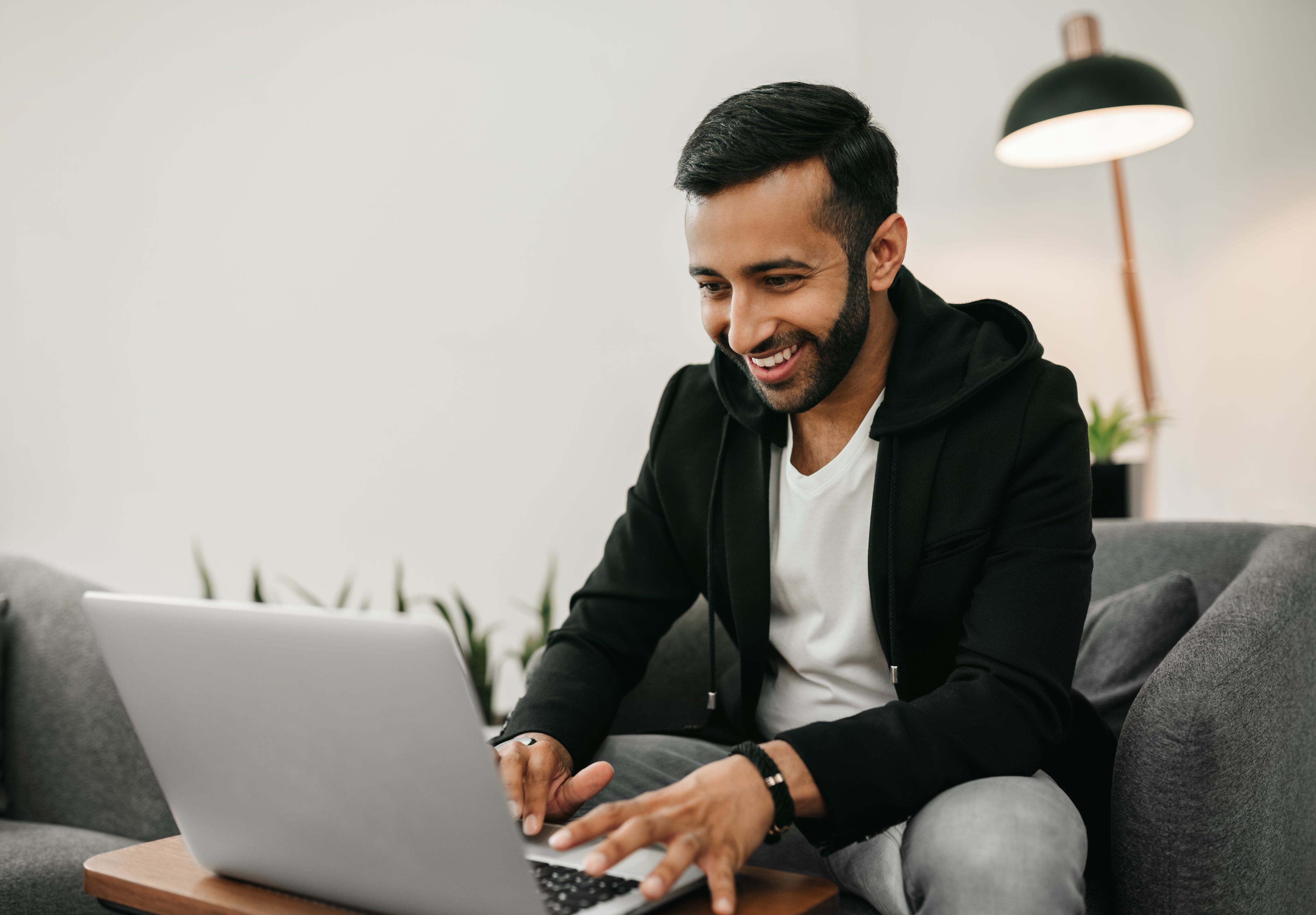 Young man smiling looking at a laptop