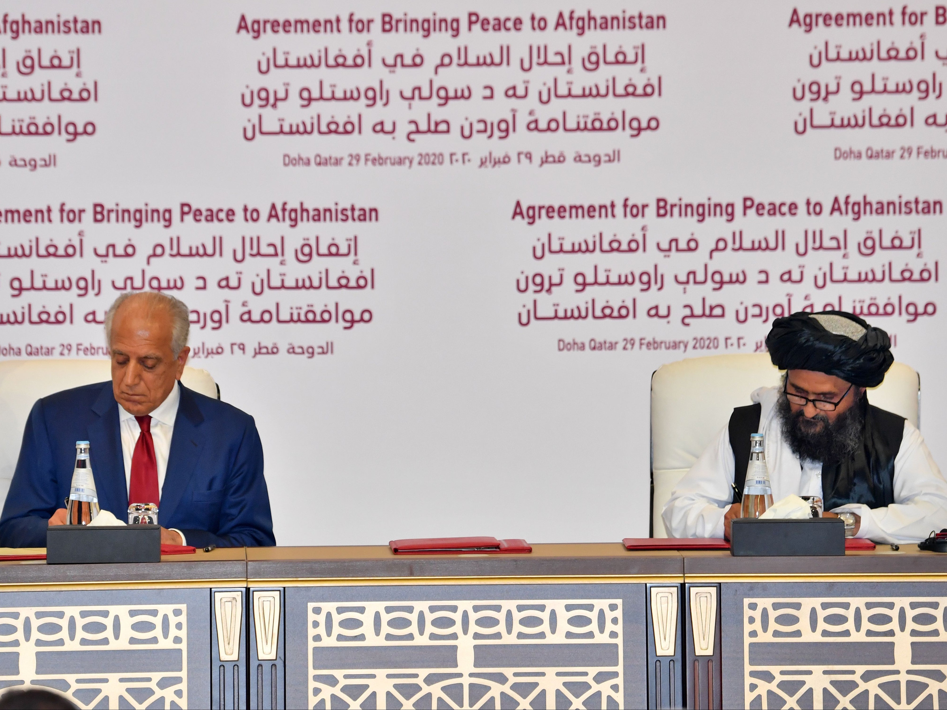 US Special Representative for Afghanistan Reconciliation Zalmay Khalilzad and Taliban co-founder Mullah Abdul Ghani Baradar sign a peace agreement during a ceremony in the Qatari capital Doha on 29 February 2020