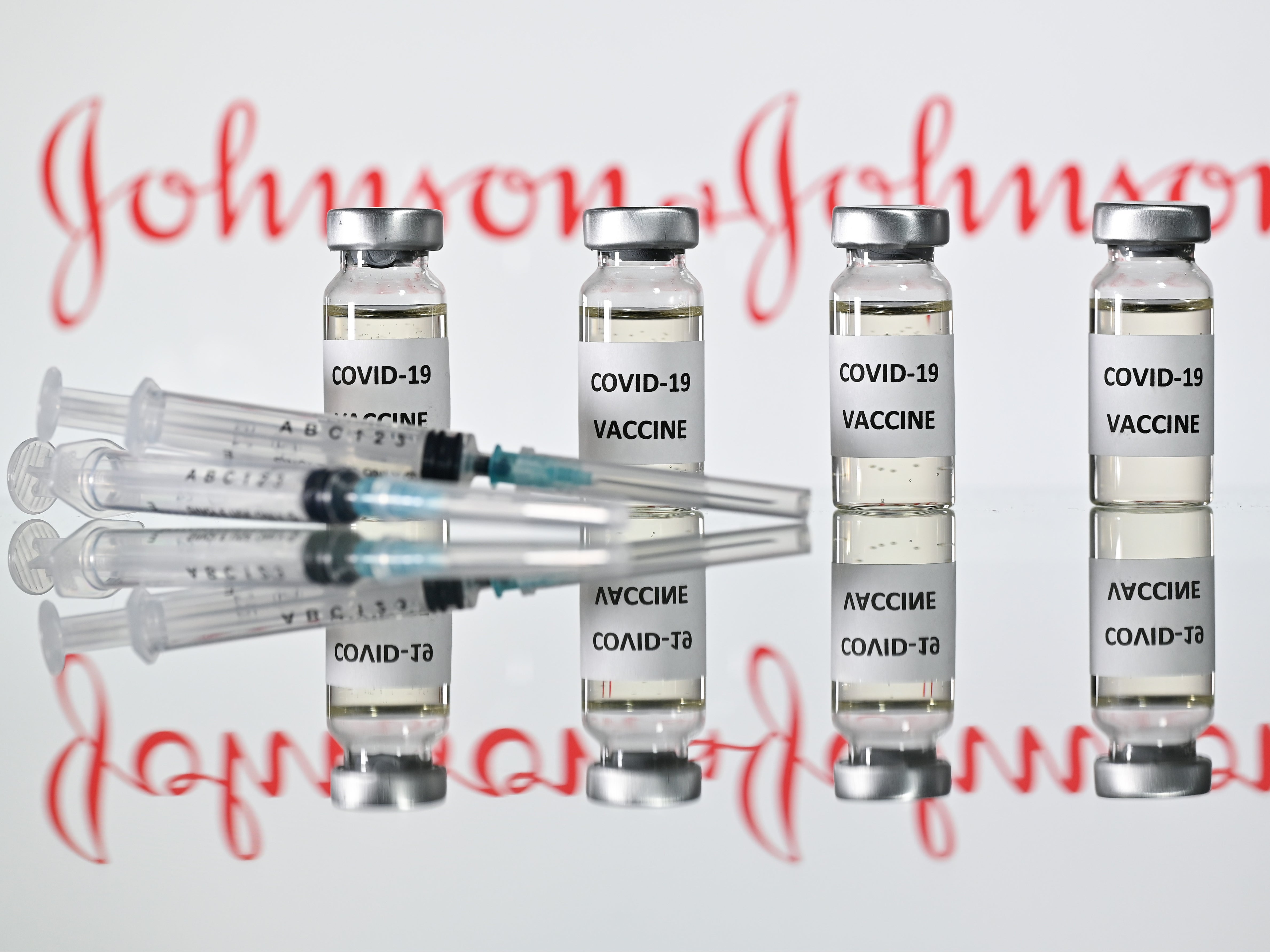 An illustration picture shows vials with Covid-19 Vaccine stickers attached and syringes with the logo of US pharmaceutical company Johnson & Johnson on 17 November 2020