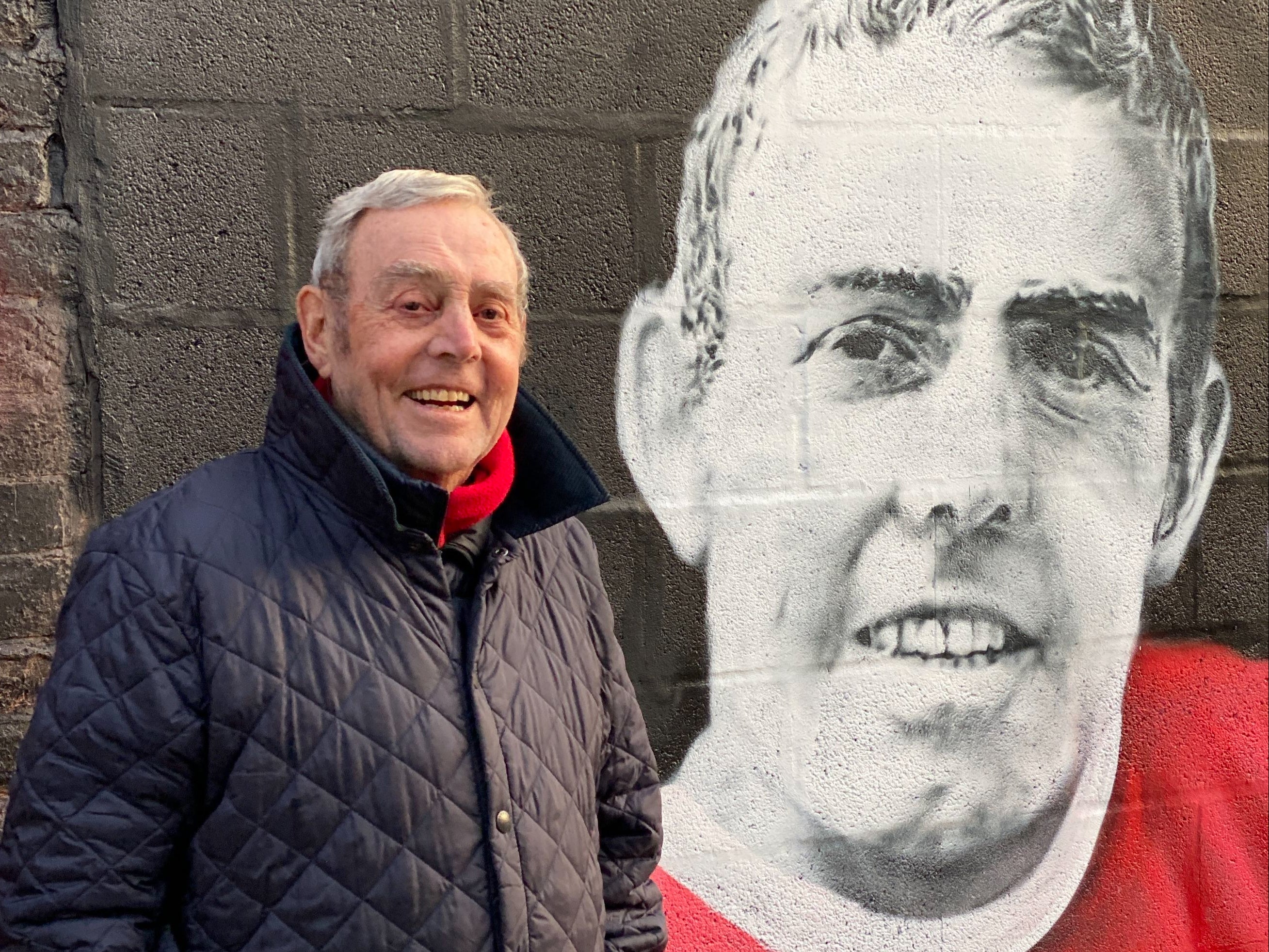 Ian St John pictured alongside a mural of himself