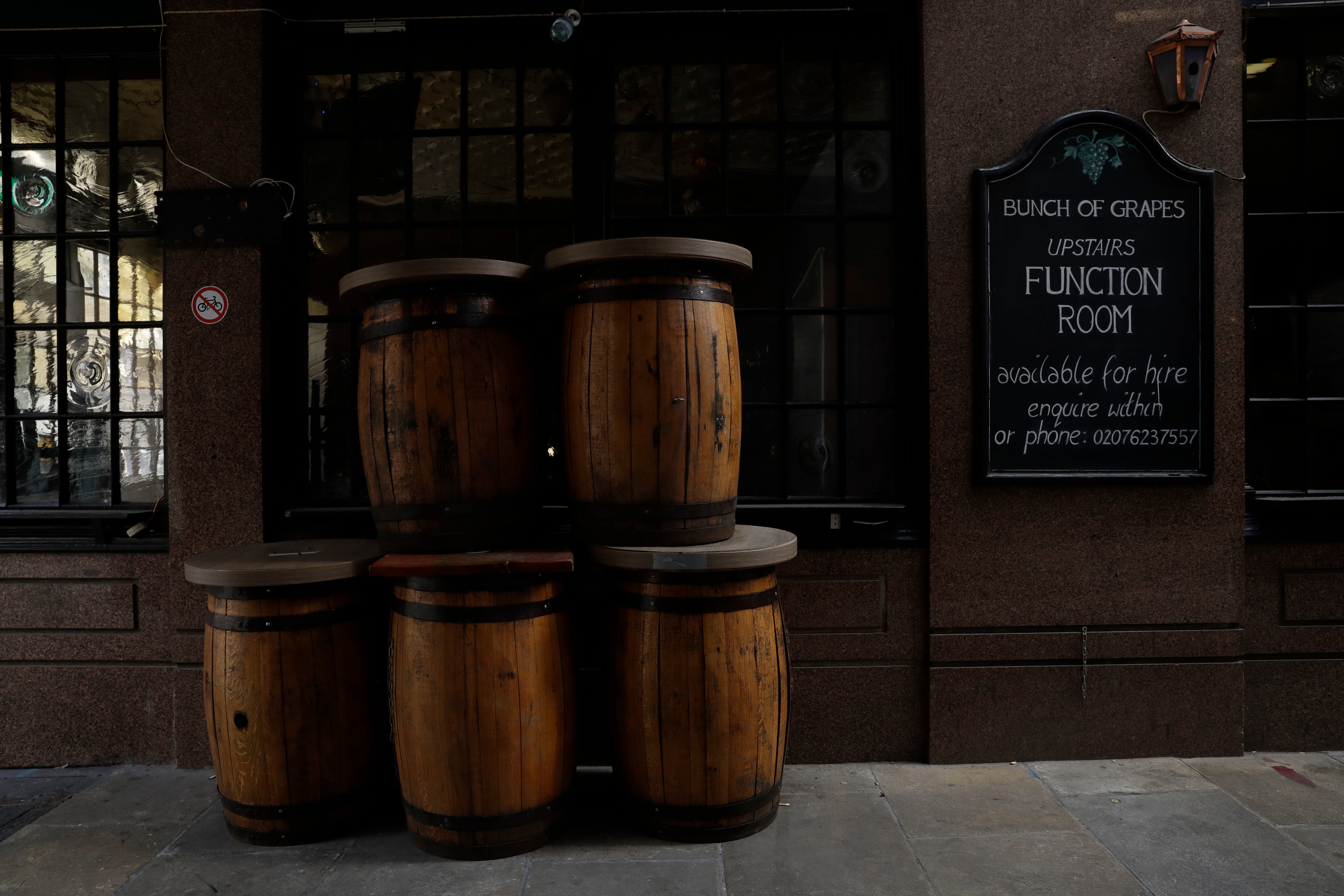 File image: Barrel tables stand stacked up outside a temporarily closed pub in London