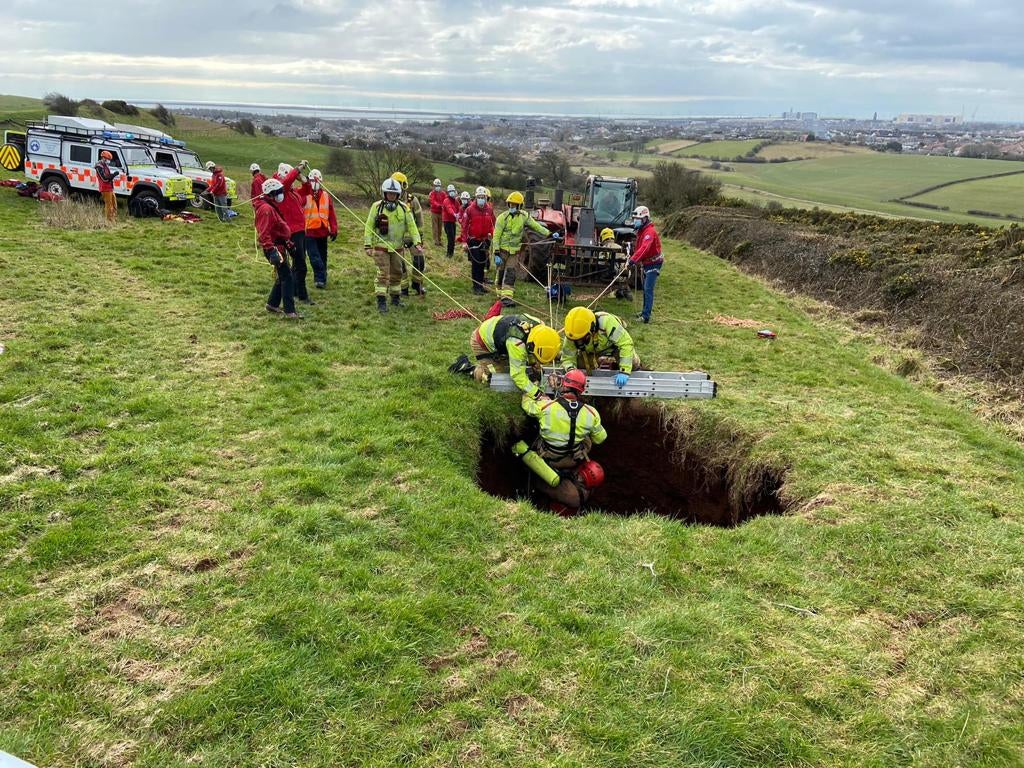 Rescuers from the Cumbria Fire and Rescue Service, and other agencies, work to pull the farmer up after he fell into a 60ft sinkhole with his quad bike