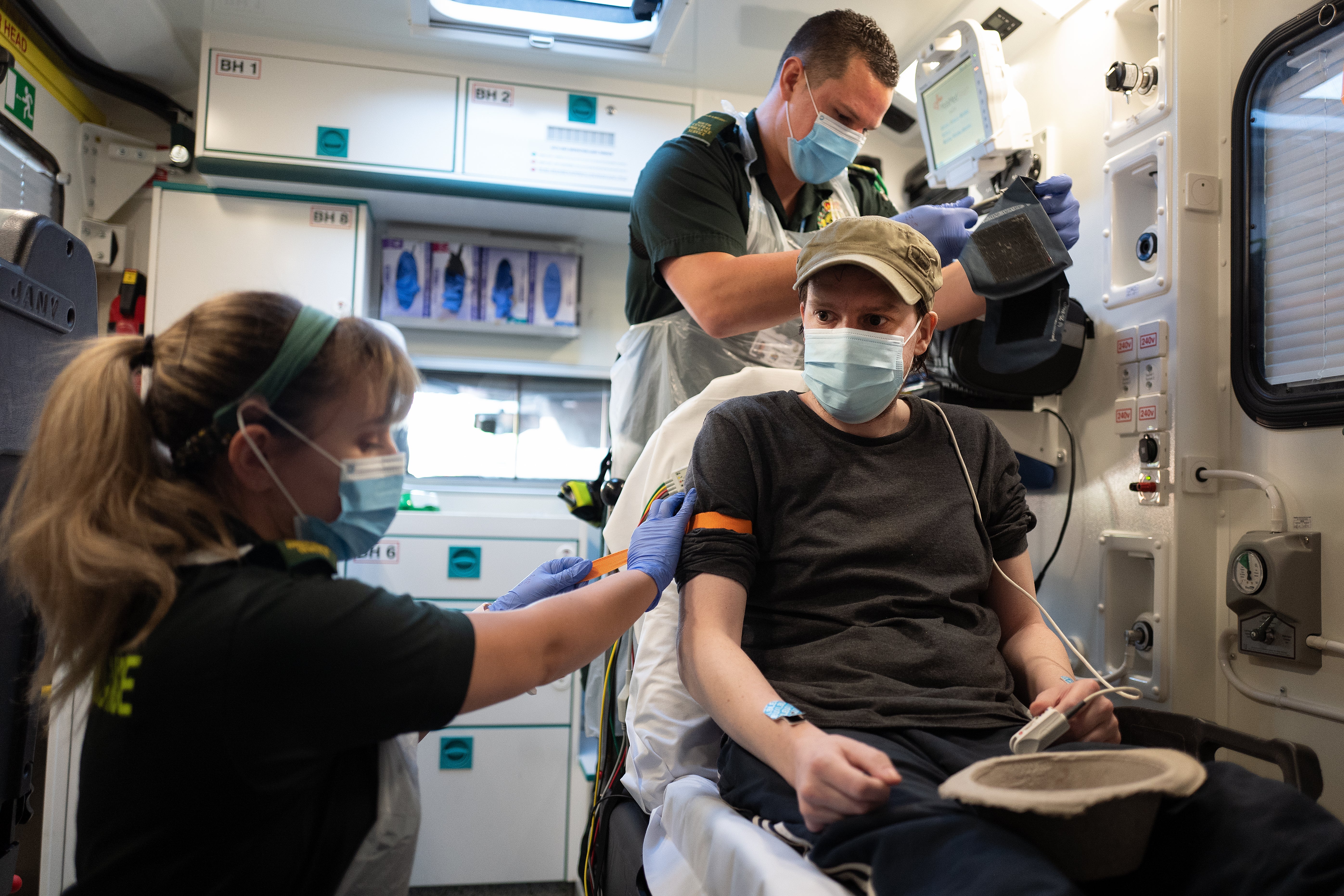 Paramedics treat a patient who tested positive for Covid-19