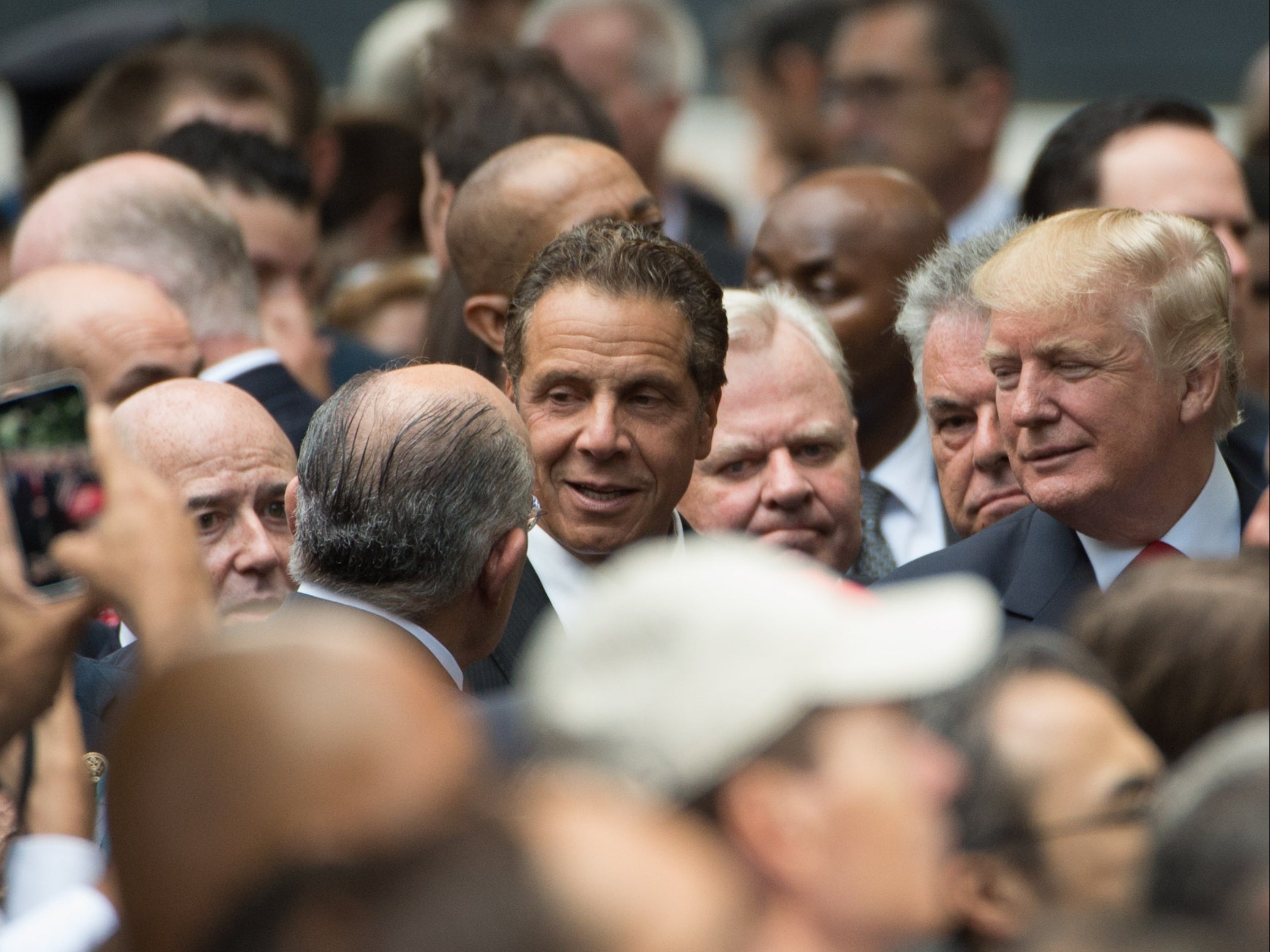 Cuomo (C) speaks with former New York City Mayor Rudolph Giuliani (L) as the then Republican presidential candidate Donald Trump looks on during an event to mark the 15th anniversary of the 9/11 attacks