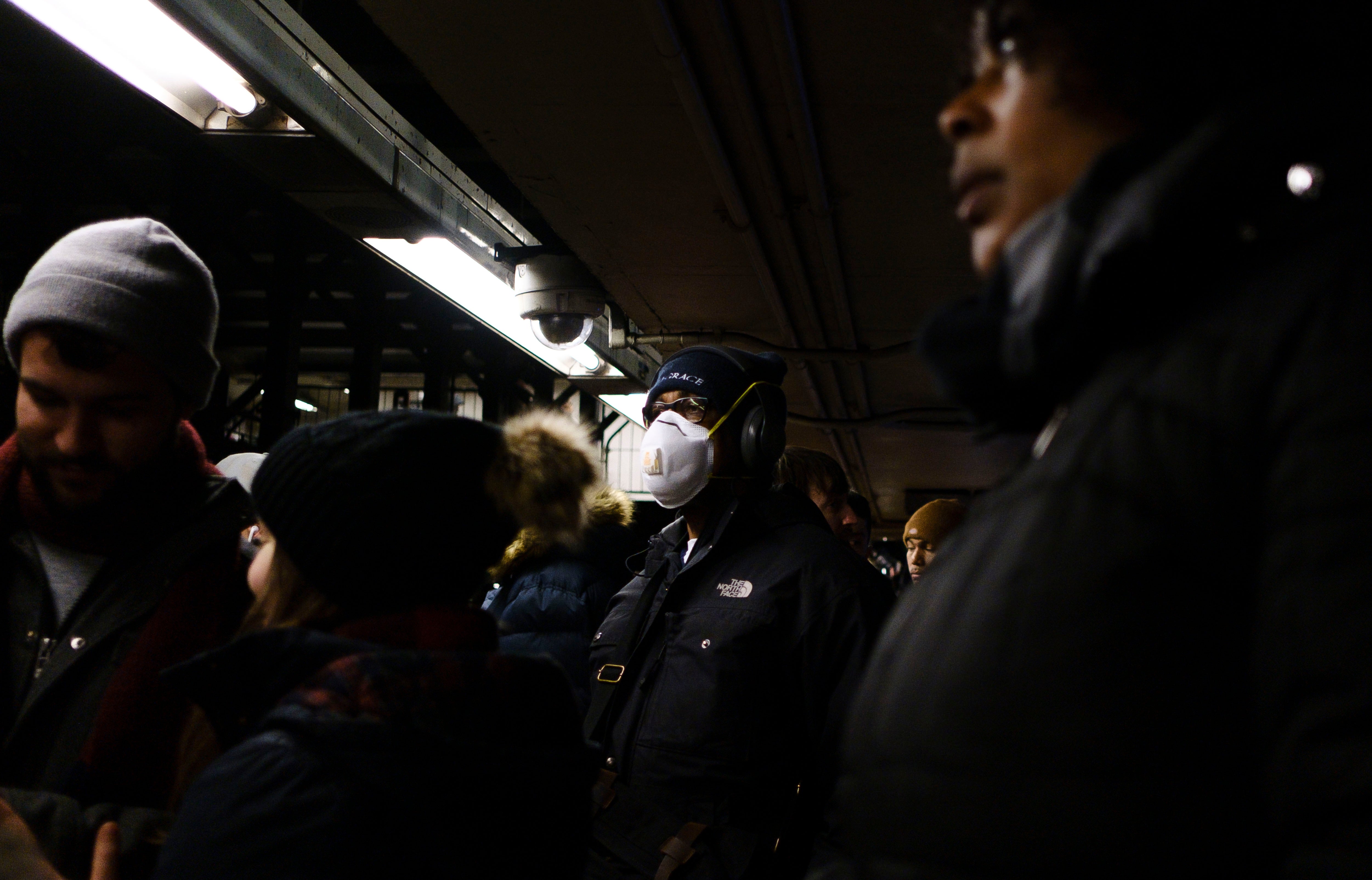 A man wears a mask while waiting for a subway train in New York