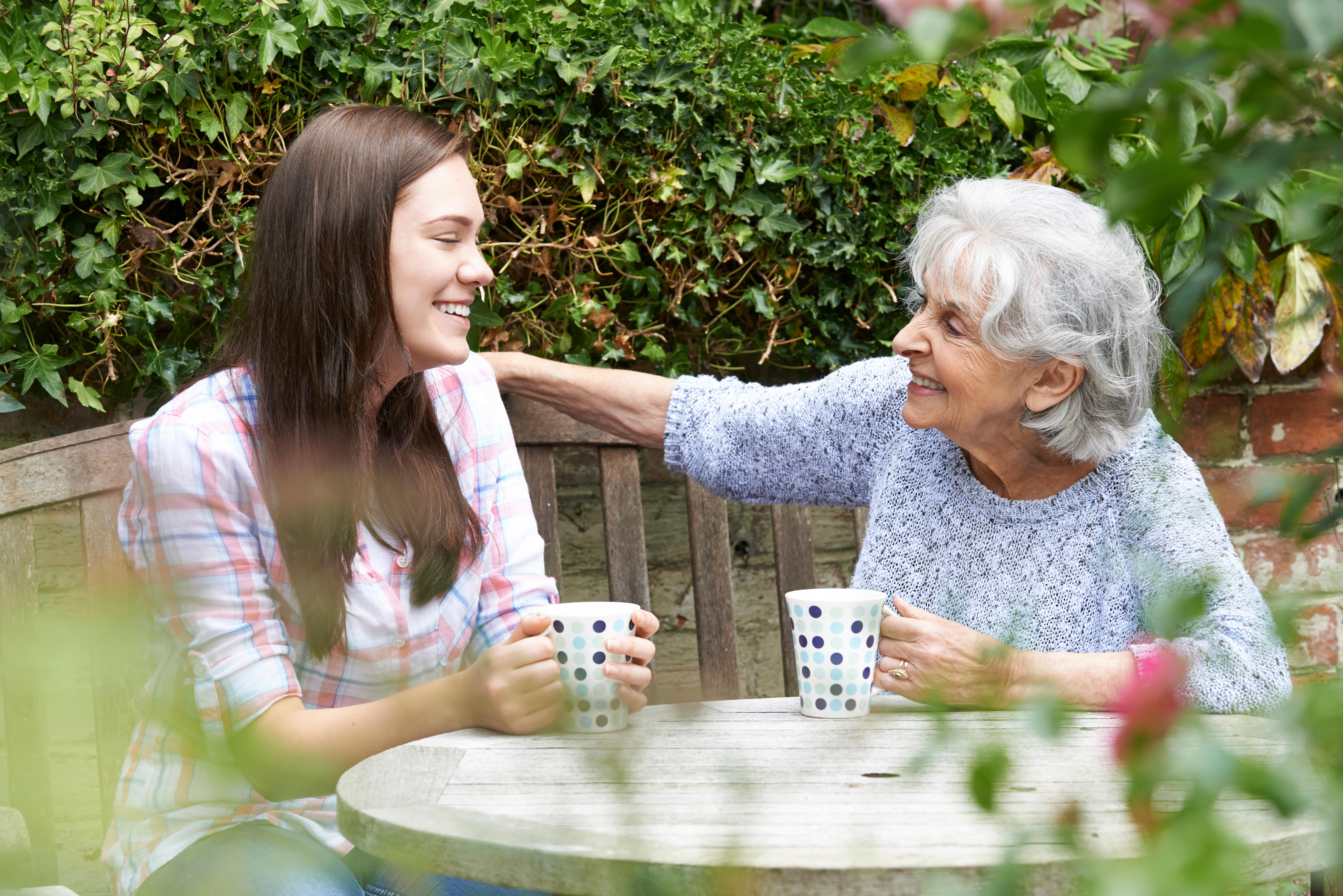 Grandmother and granddaughter chatting over tea