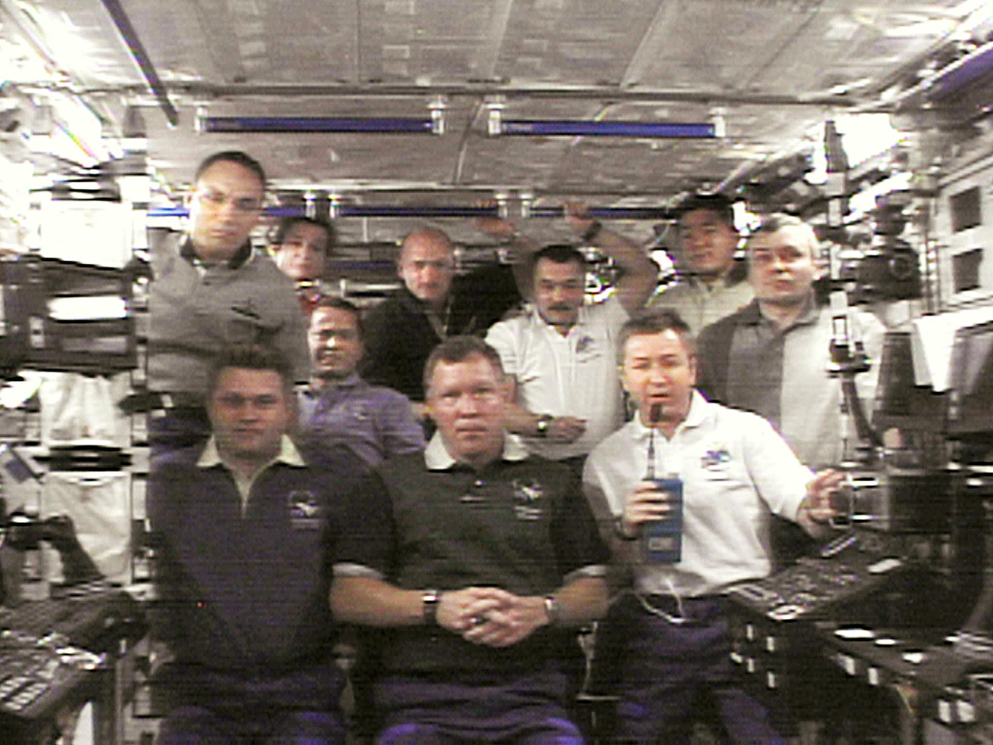 The crews of the International Space Station (ISS) and the US space shuttle Endeavour gather during a video down link 09 December 2001 from the station discussing commemorative items they have on board for the victims and heroes of the 11 September terrorist attacks on the US. Commander Culberton bottom right