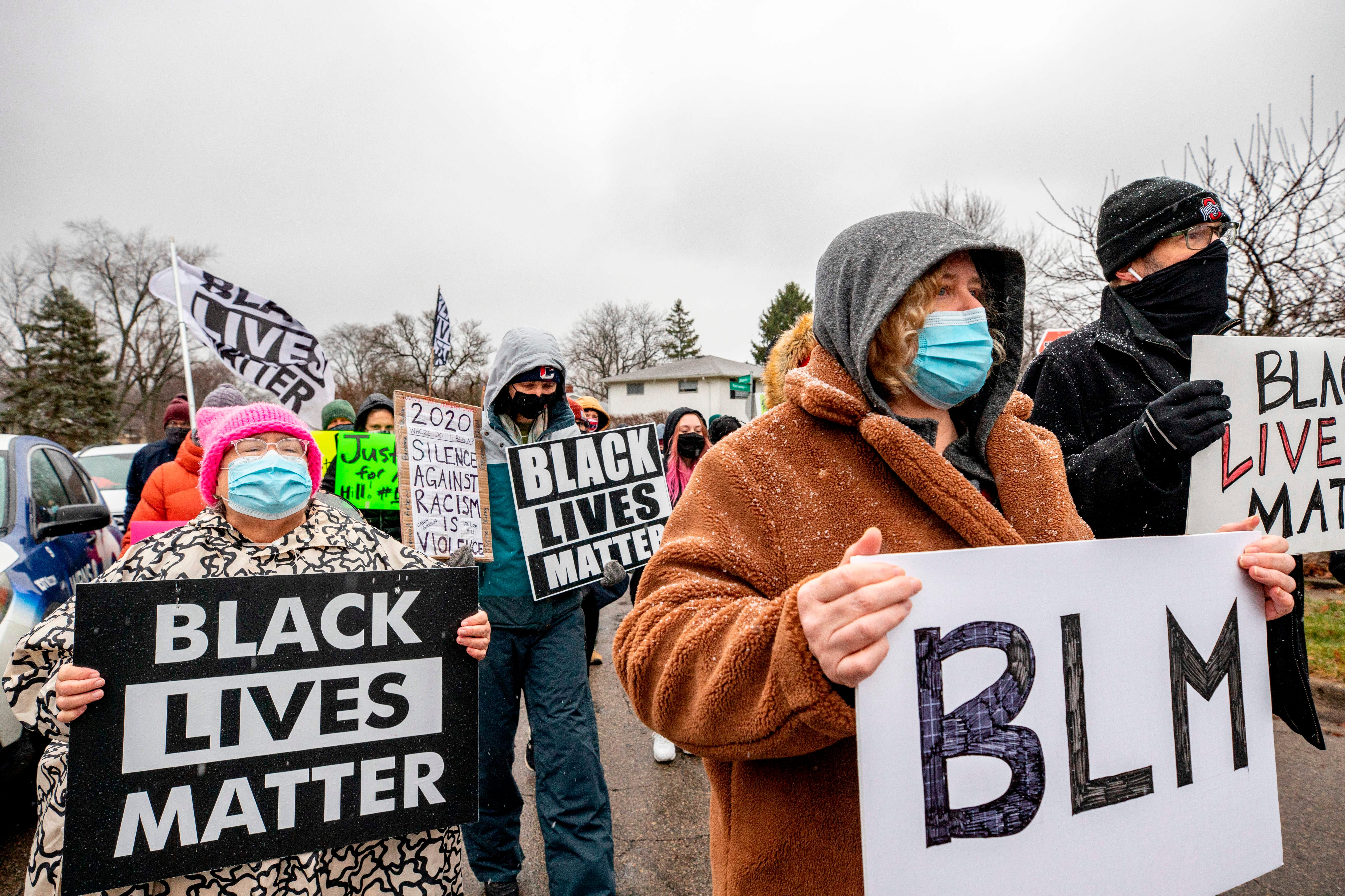 Shawn Finley, a resident and protest organizer, holds a BLM sign as she marches along with protesters in a demonstration against the police killing of Andre Hill in the neighborhood where Hill was shot, in Columbus, Ohio on December 24, 2020. (Photo by STEPHEN ZENNER / AFP)