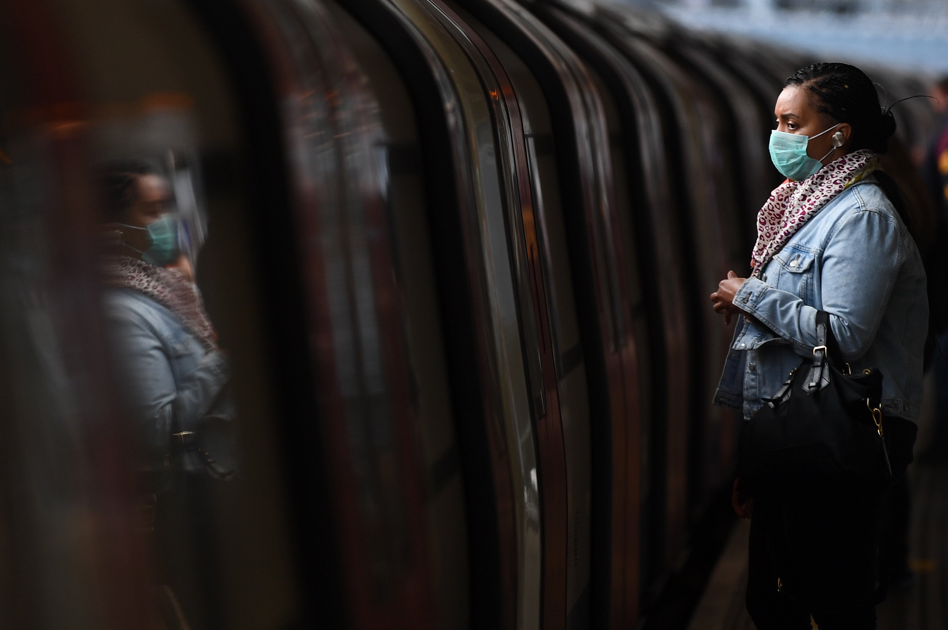 A passenger wears a face mask on a platform at Canning Town underground station in London, after the announcement of plans to bring the country out of lockdown in May 2020.