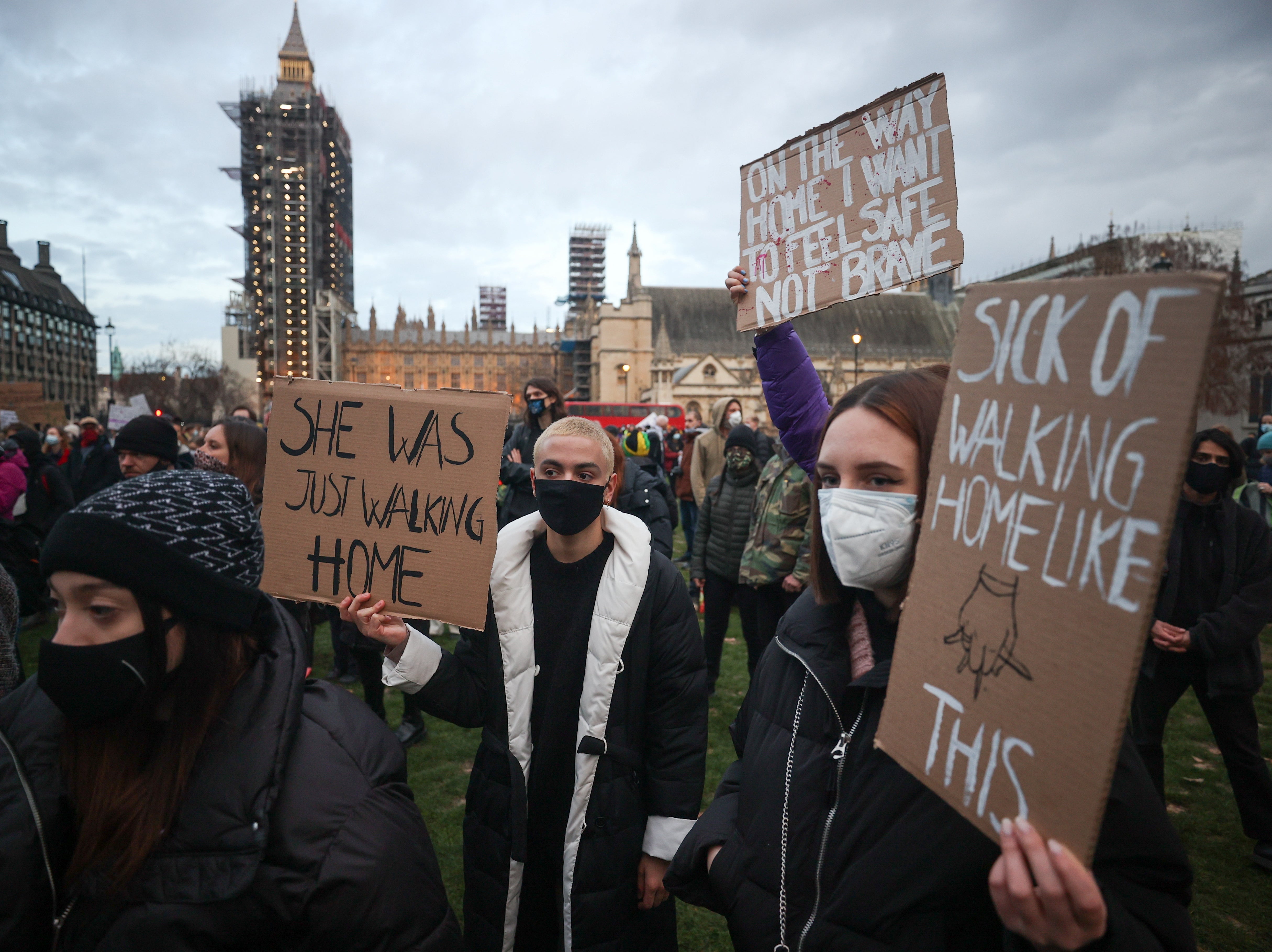 Demonstrators outside Parliament on Monday wield signs referring to Sarah Everard who was "just walking home" before her death, and pointing to many women's experience of walking home with their keys between their fingers as a form of self-defence against potential attackers.