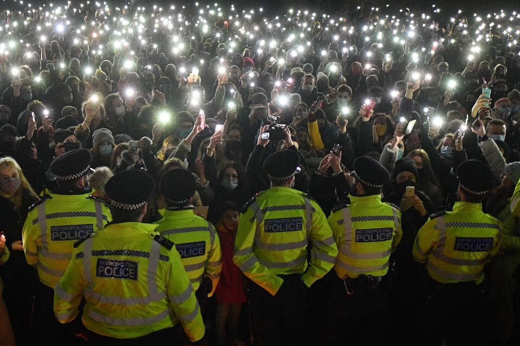 Police officers form a cordon at vigil for alleged murder victim Sarah Everard on 13 March.