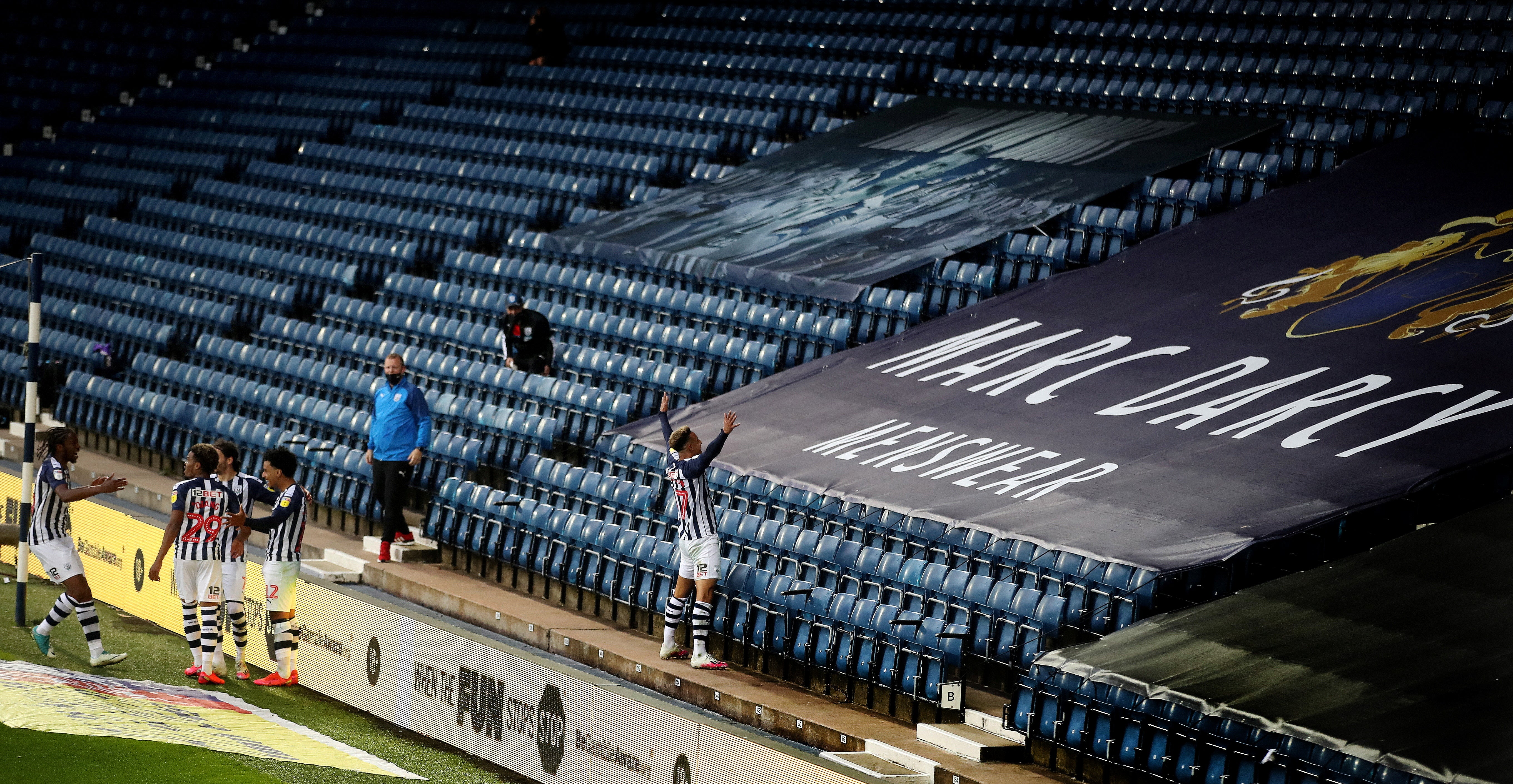 West Brom’s Callum Robinson celebrates scoring in front of an empty stand, in the game that sealed their promotion back to the Premier League in July