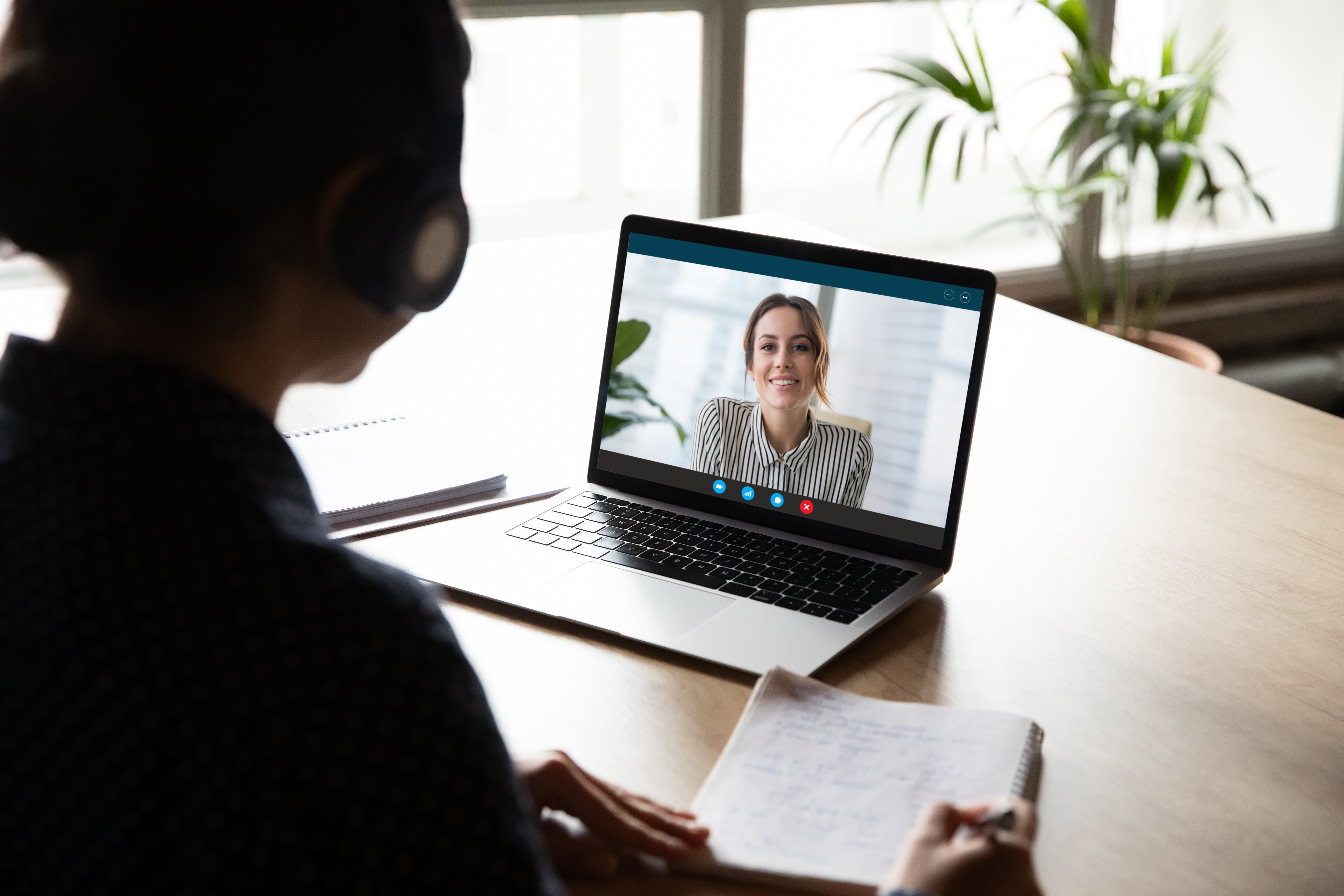 Back view of female employee have web conference with coworker