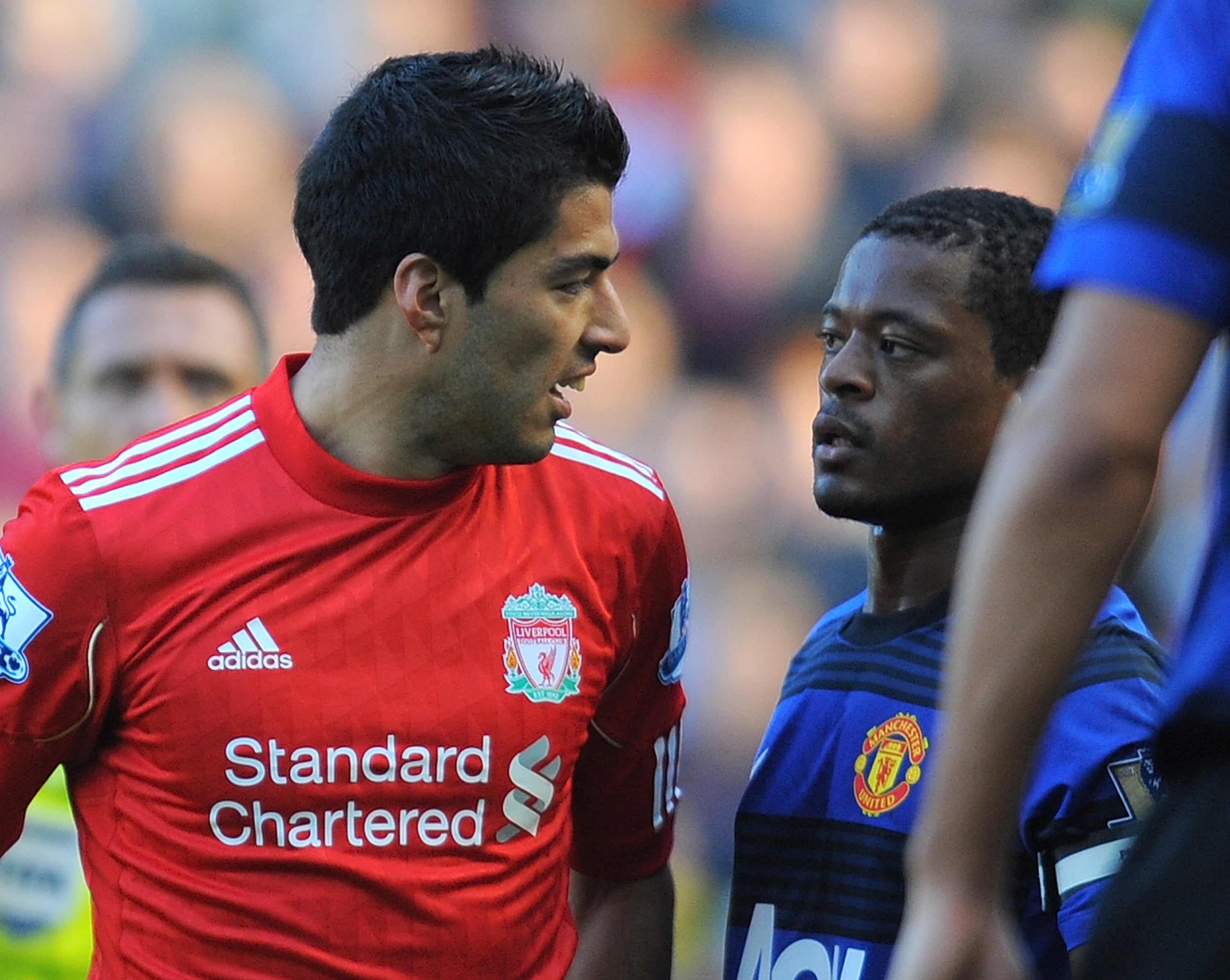 Luis Suarez exchanges words with Manchester United's French defender Patrice Evra