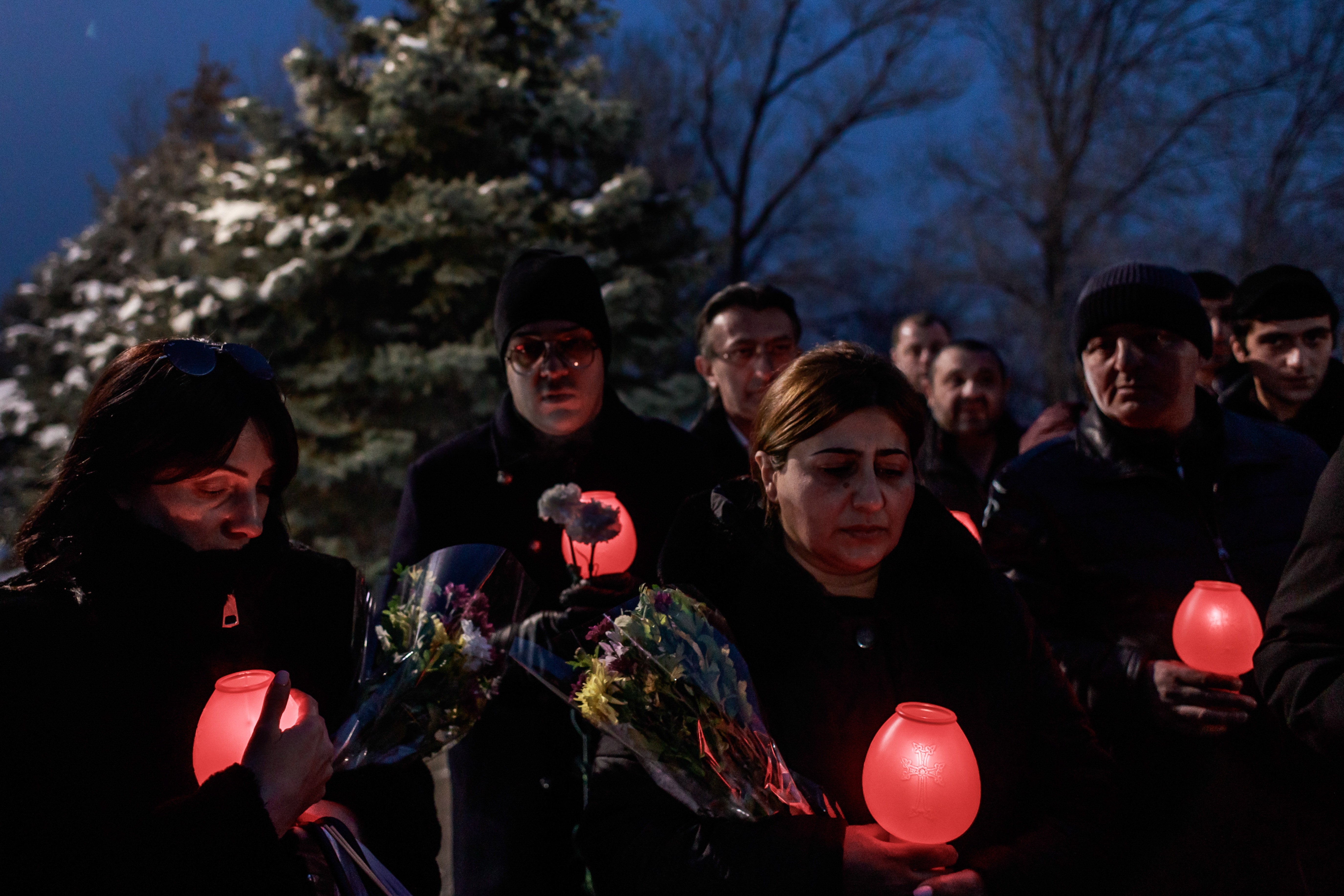 Relatives and friends of a killed soldier hold a vigil in a cemetery in Yerevan