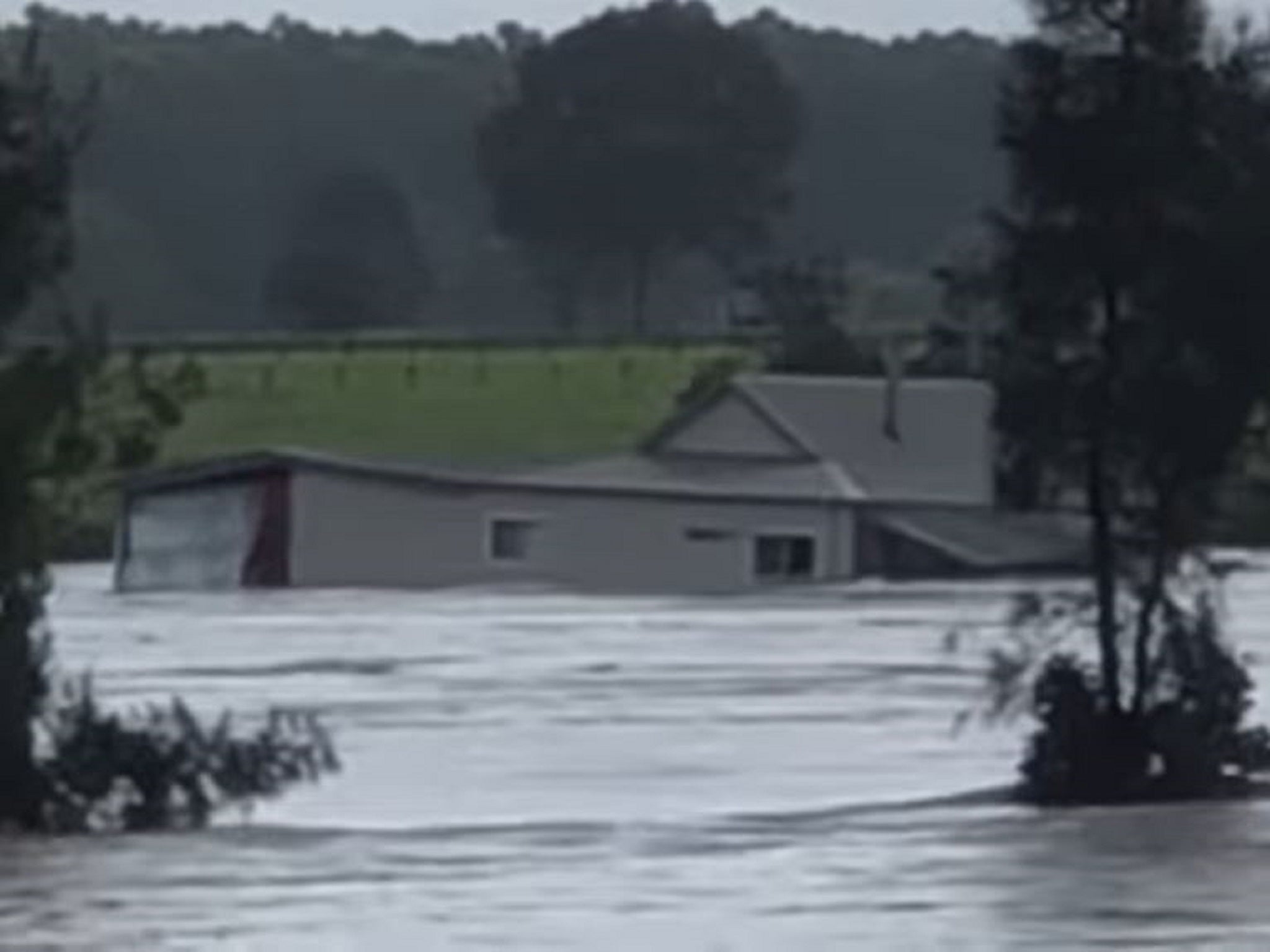 A cottage is swept down the Manning River near Mondrook in New South Wales, Australia, during heavy flooding