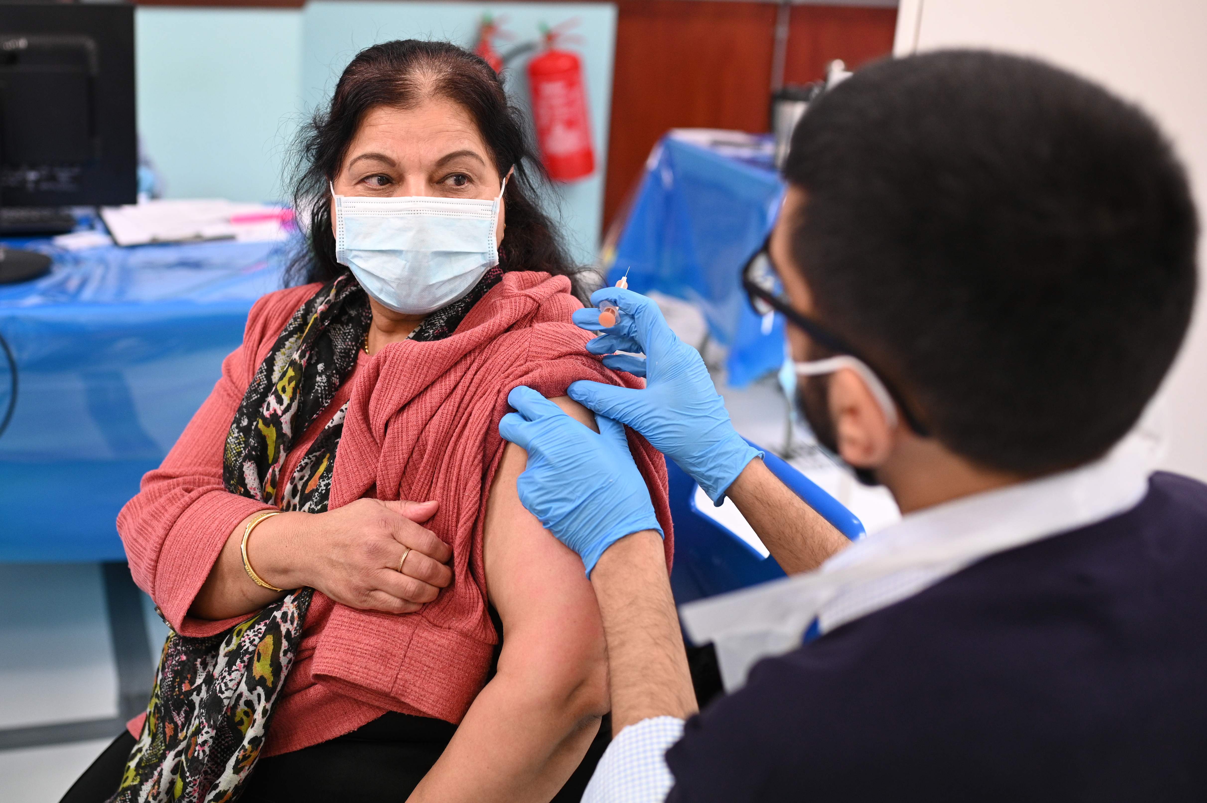 Pharmacist, Minhal Master (R) administers a dose of the AstraZeneca/Oxford Covid-19 vaccine at a temporary vaccination centre, staffed by pharmacists and pharmacist assistants, at the Al-Abbas Islamic Centre in Birmingham, West Midlands