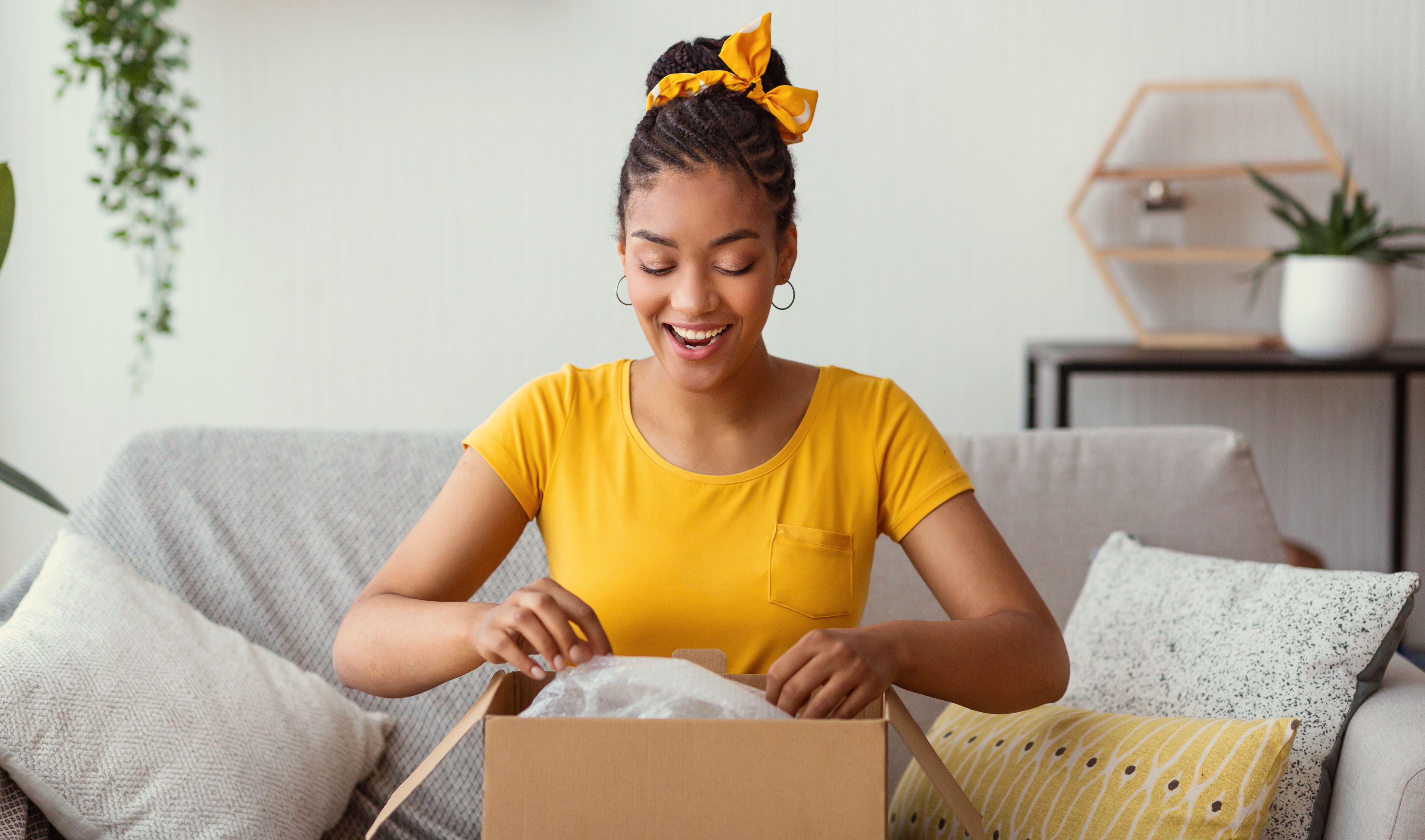 Woman opening a parcel and looking delighted