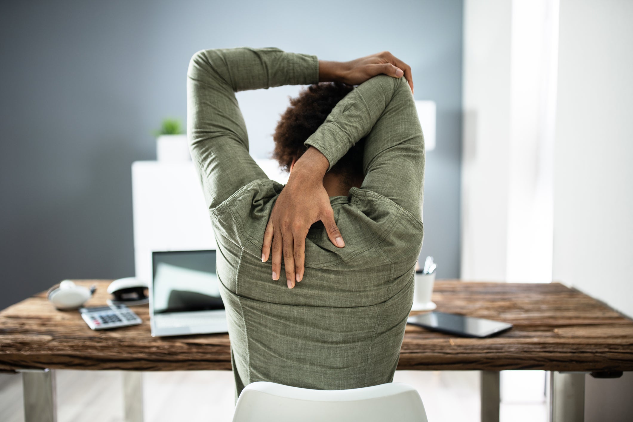 Rear view of man stretching his triceps