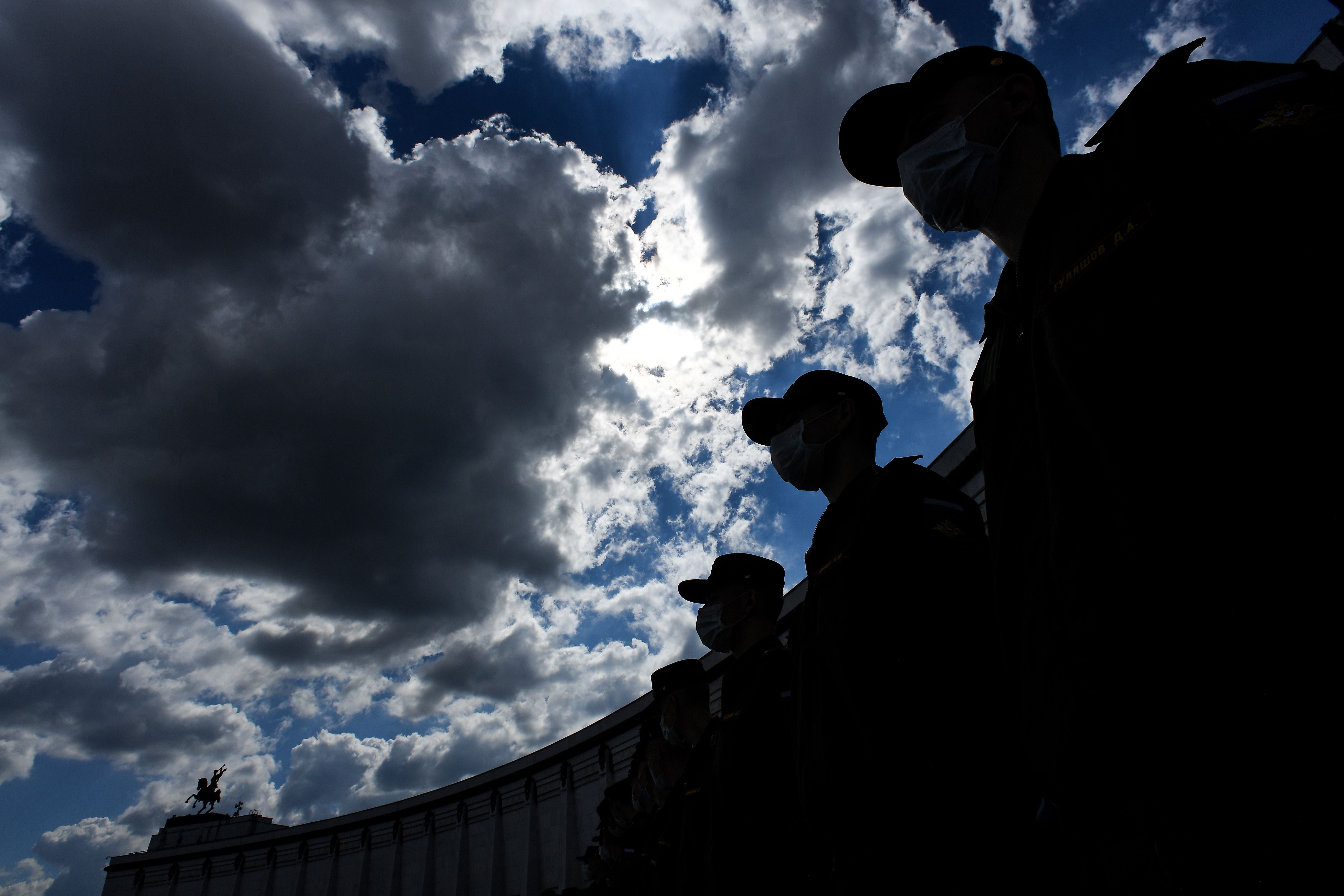 Russian servicemen wearing a face mask to prevent the spread of the novel coronavirus (covid-19) pandemic, prepare to roll out a Russian national flag during a celebration ceremony of the National Flag Day at Poklonnaya Hill in Moscow on 22 August, 2020.