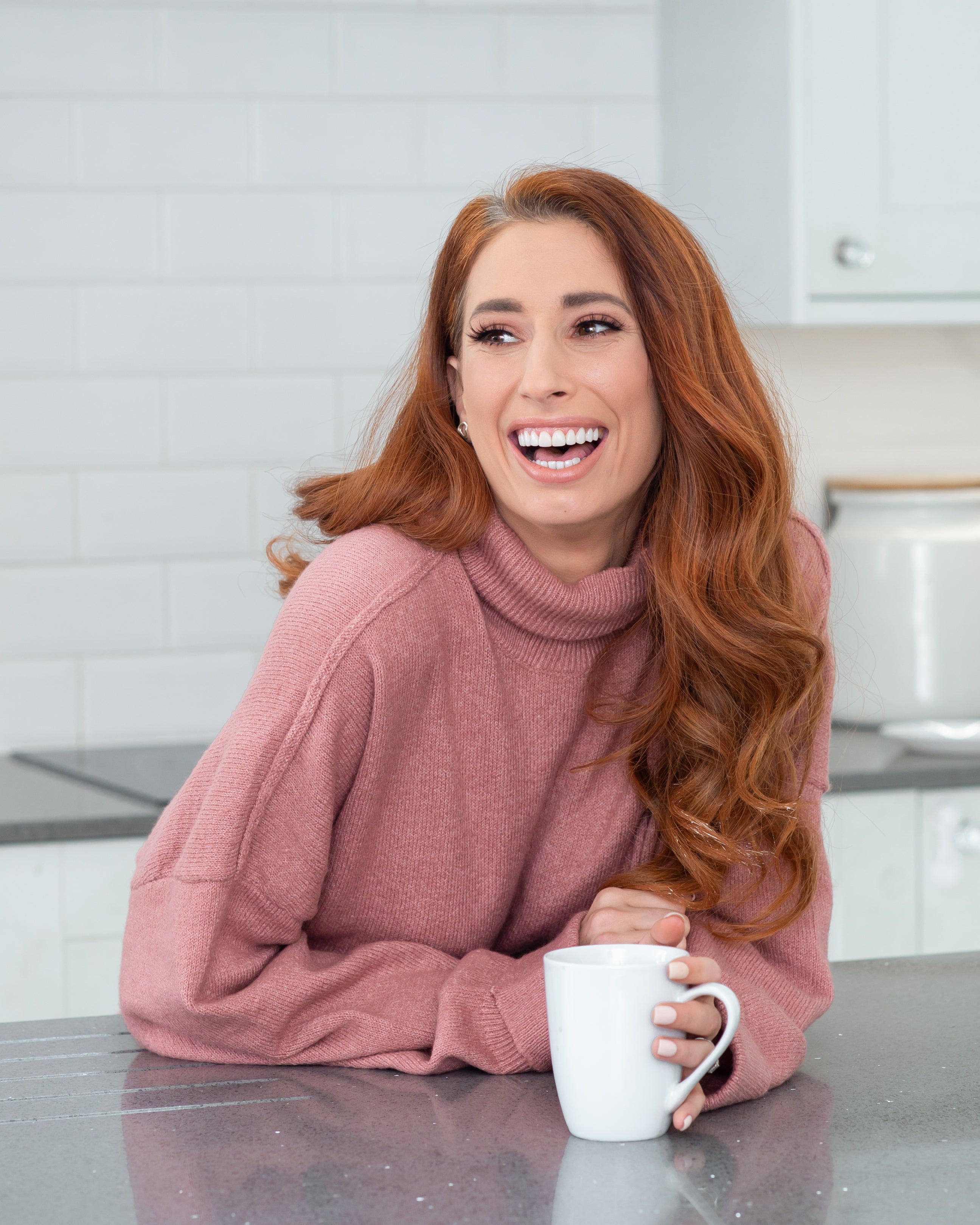 Stacey Solomon in a pink jumper at home, laughing and happy