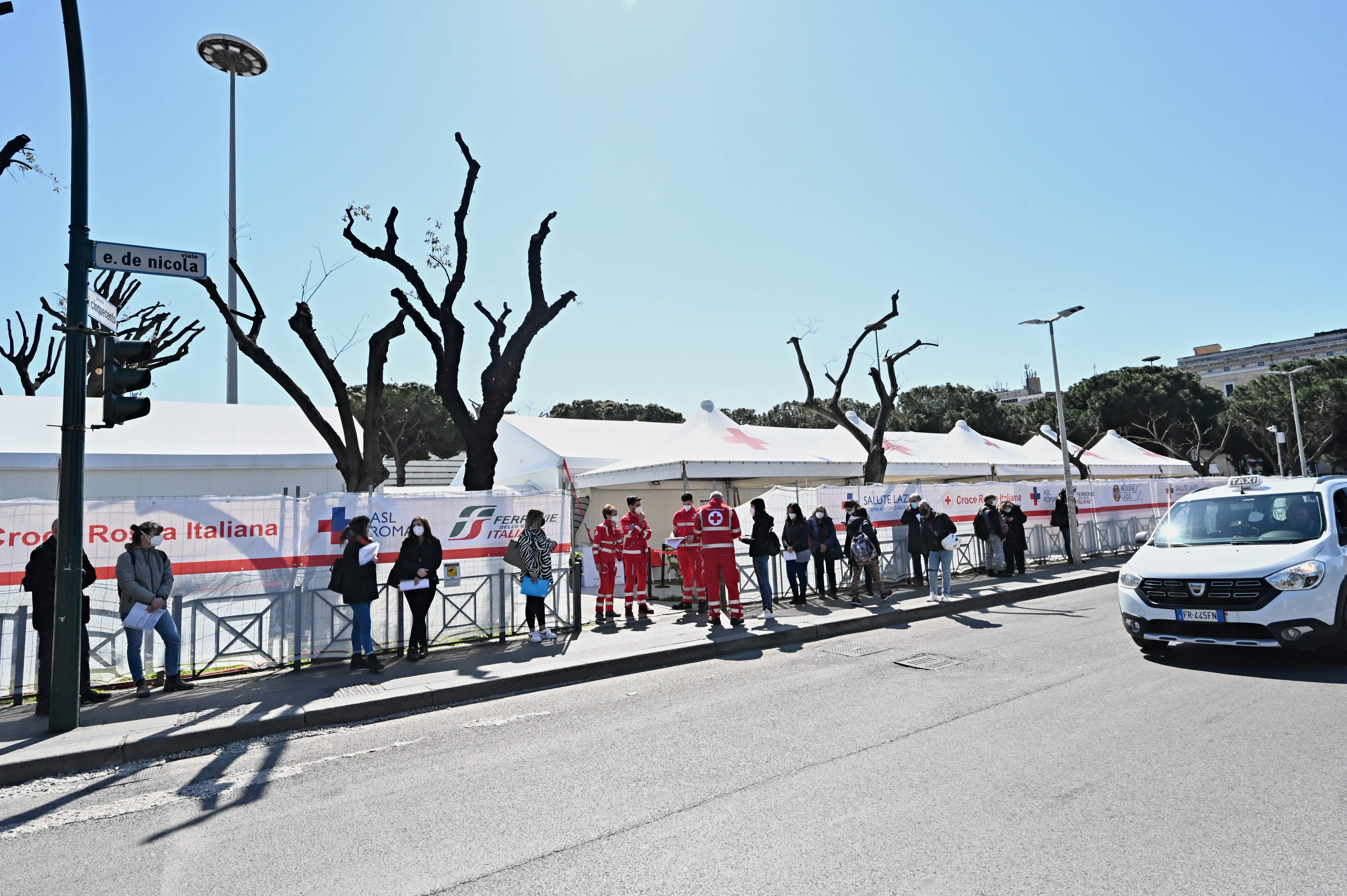 People coming to be vaccinated with the AstraZeneca vaccine, wait in line on March 24, 2021 prior to enter a vaccination hub set up outside Rome's Termini railway station