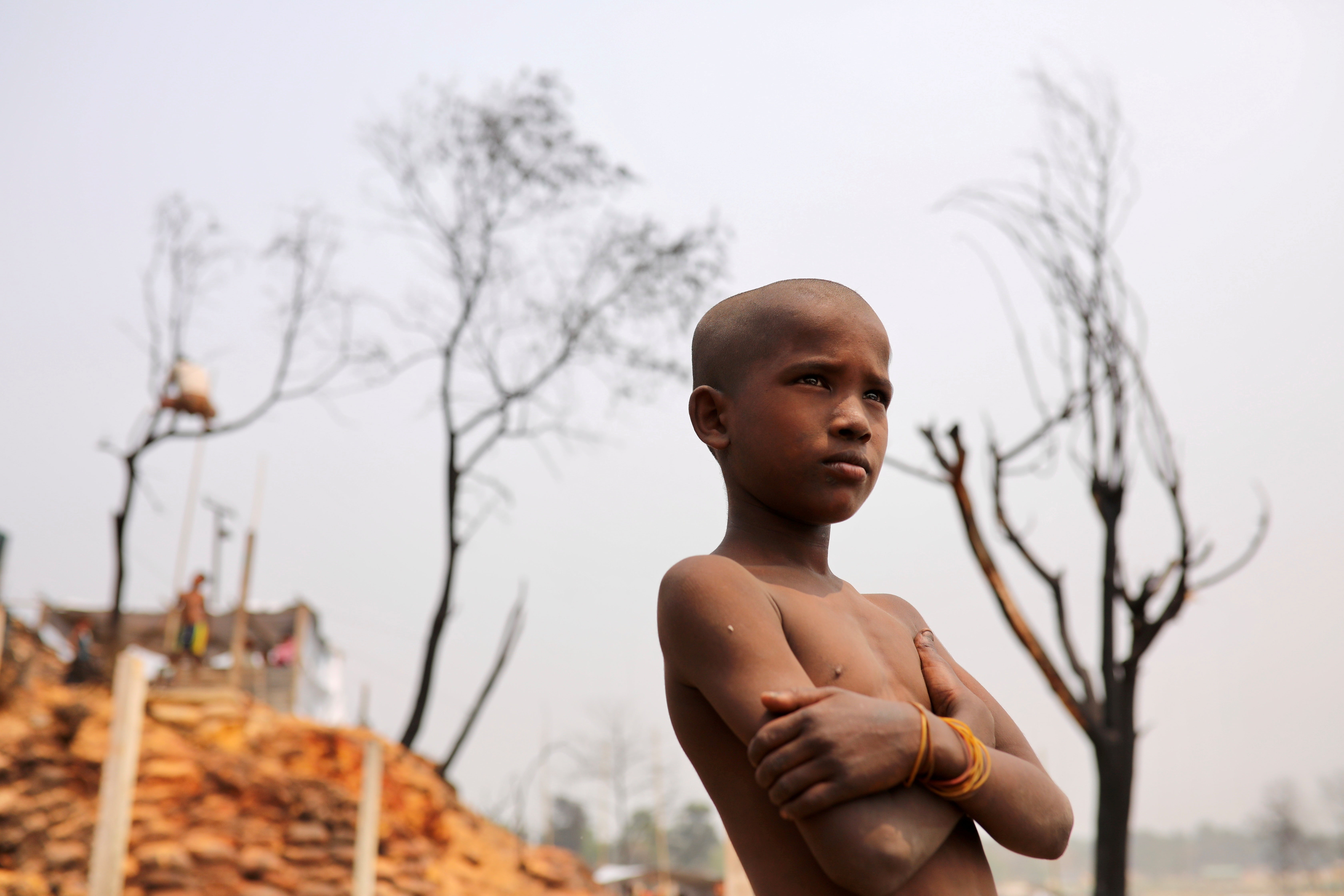 A Rohingya refugee boy stands amid the damage after the fire